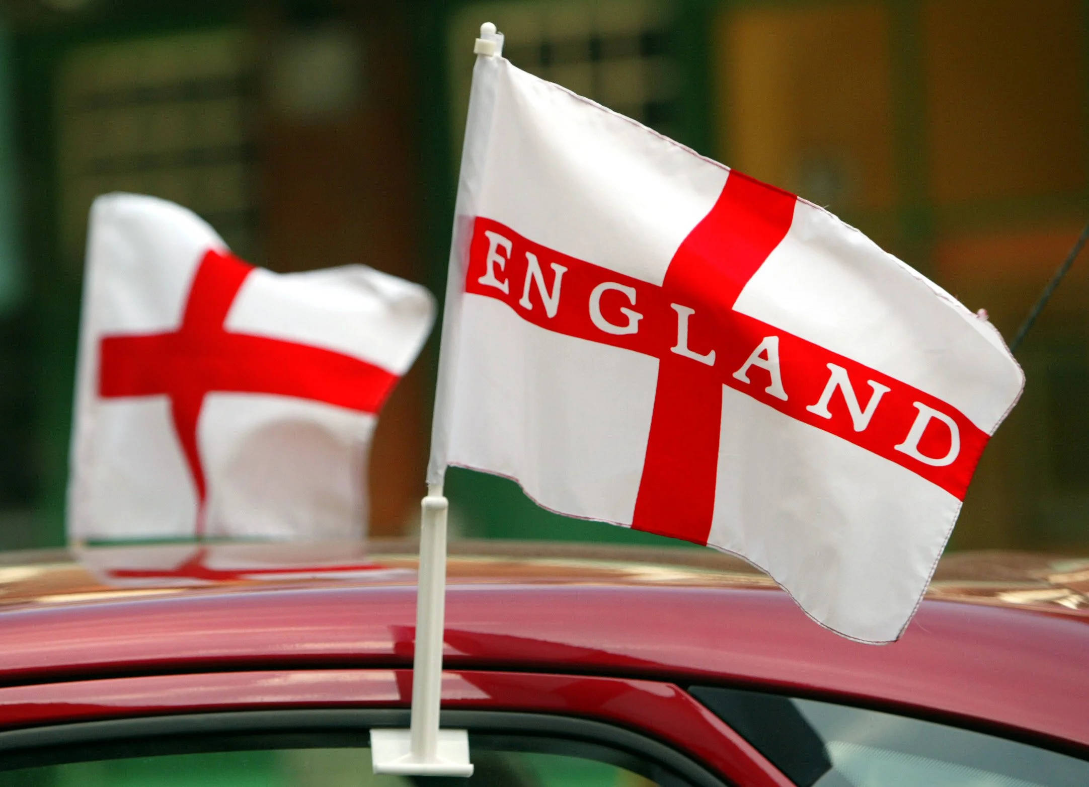England Flag 桌布 壁紙 — 兩面英格蘭旗幟在紅色車頂上飄揚，其中一面清楚標有粗體紅色字樣。