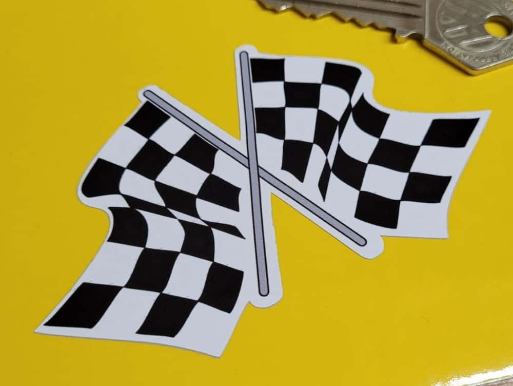 Chequered Flag 桌布 壁紙 — 兩面黑白格紋賽車旗交叉放在亮黃色表面上，附近有一串鑰匙。