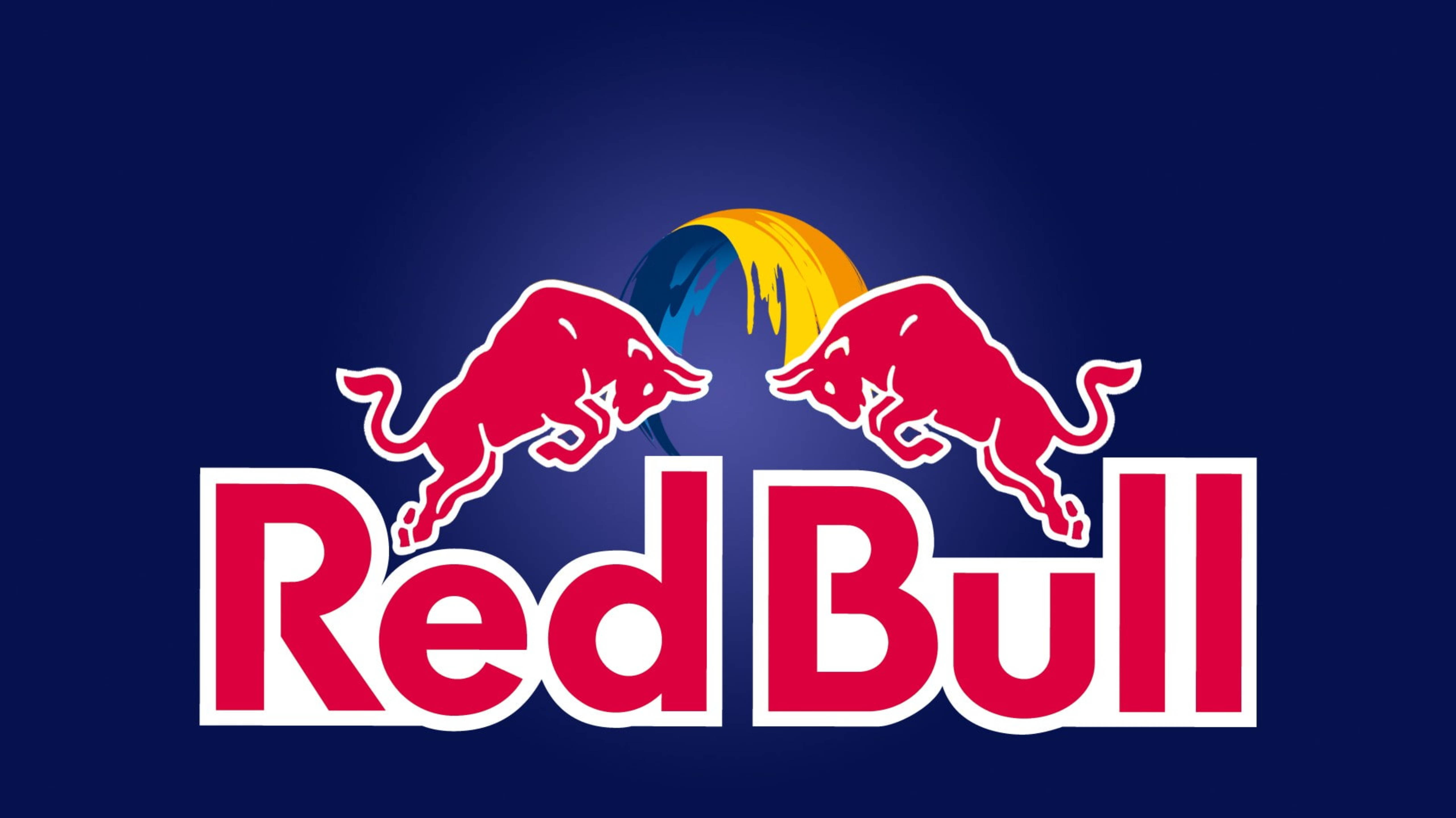 bull 桌布 壁紙 — 兩頭紅牛在深藍色背景上互相跳躍，上方有黃色和藍色的太陽光芒，以及粗體紅色的「Red Bull」文字。