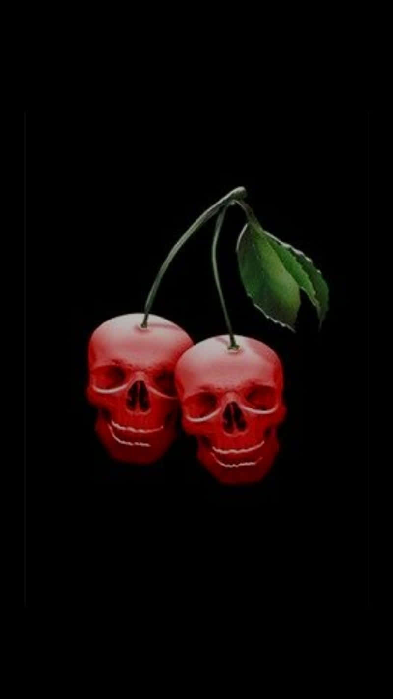Skull Phone 桌布 壁紙 — 兩顆光澤的紅色櫻桃，形狀像骷髏頭，帶有綠色莖和葉子，背景為黑色。