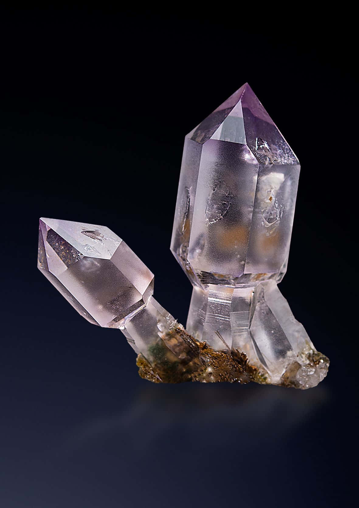 水晶 桌布 壁紙 — 兩顆半透明紫水晶晶體，尖端呈紫色，高高矗立在黑色背景的深色底座上。