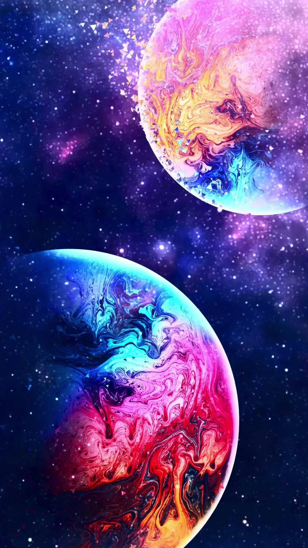 兩顆旋轉的彩色行星在繁星點點的宇宙虛空中，伴隨著發光的粒子。 — 可愛的銀河動圖 壁紙