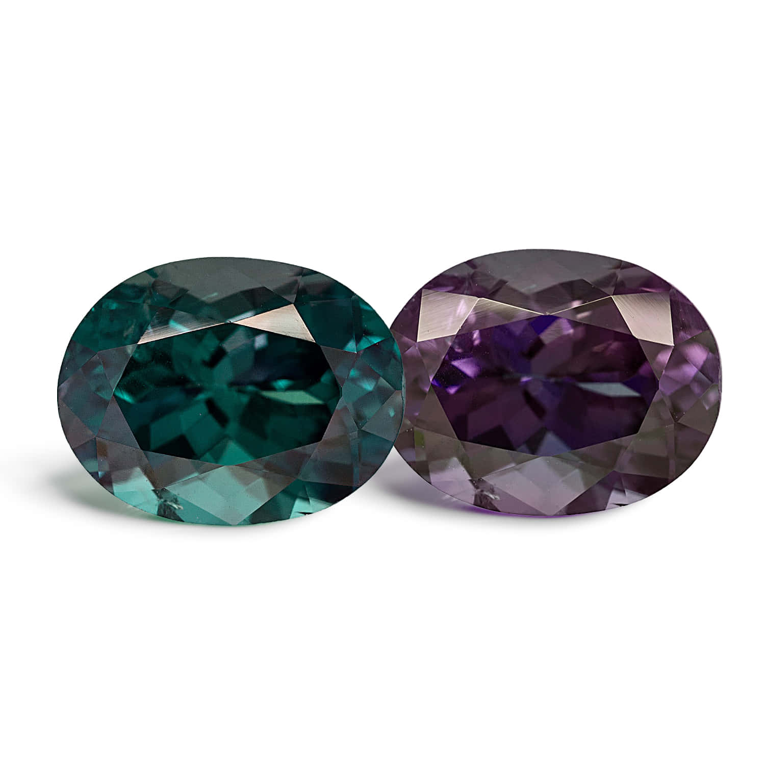 Gem Stone 桌布 壁紙 — 兩顆橢圓形刻面寶石，一顆藍綠色，一顆深紫色，在純白背景上閃耀。