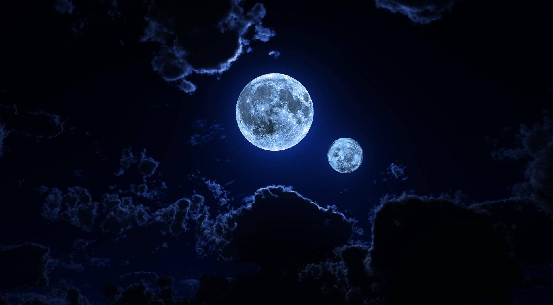 雲朵 桌布 壁紙 — 兩顆發光的月亮穿過深藍色夜空中的烏雲閃耀。