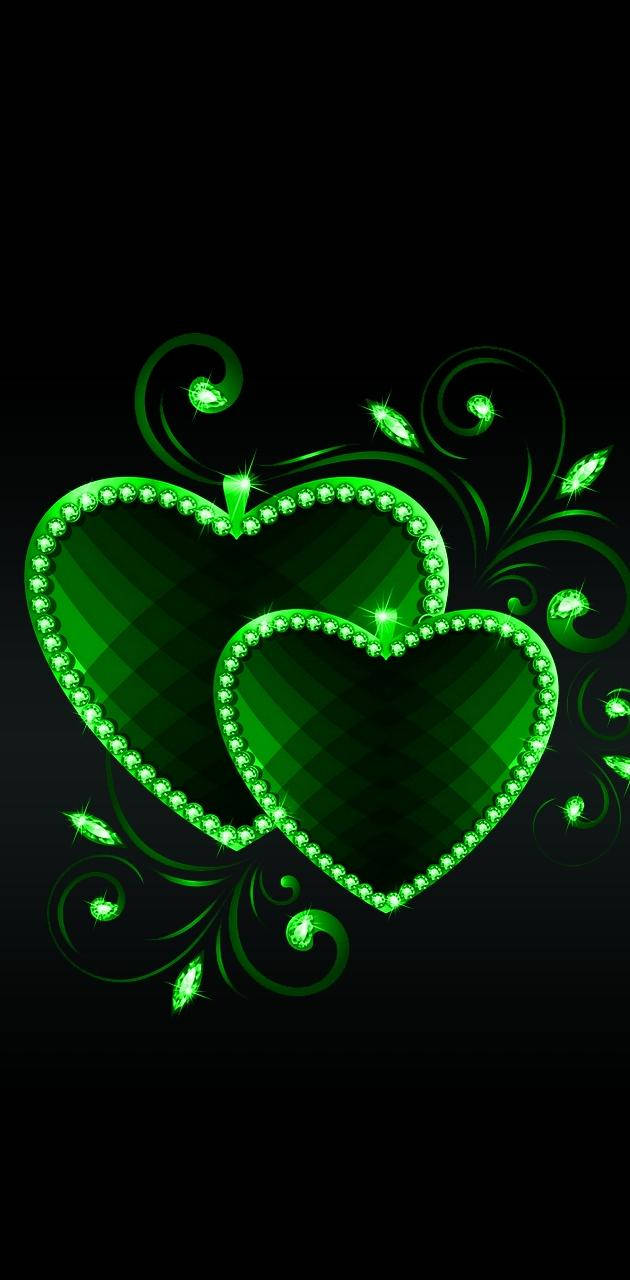 Green Heart 桌布 壁紙 — 兩顆發光的綠色寶石心臟纏繞著旋轉的藤蔓，在黑色背景上。