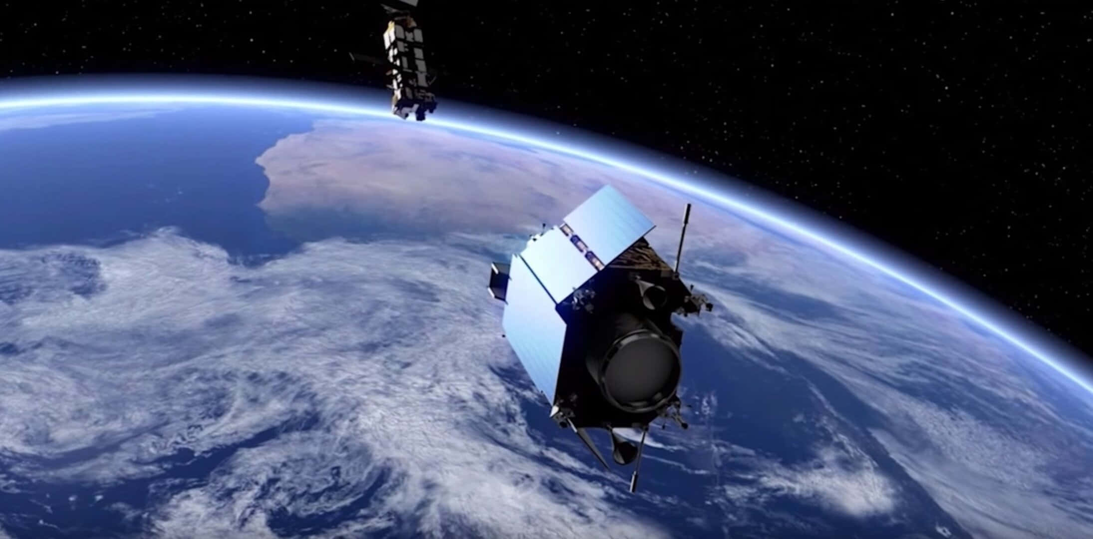 Space Satellite 桌布 壁紙 — 兩顆衛星在繁星點點的黑色天空中繞地球運行，下方是藍色的海洋和白色的雲層。