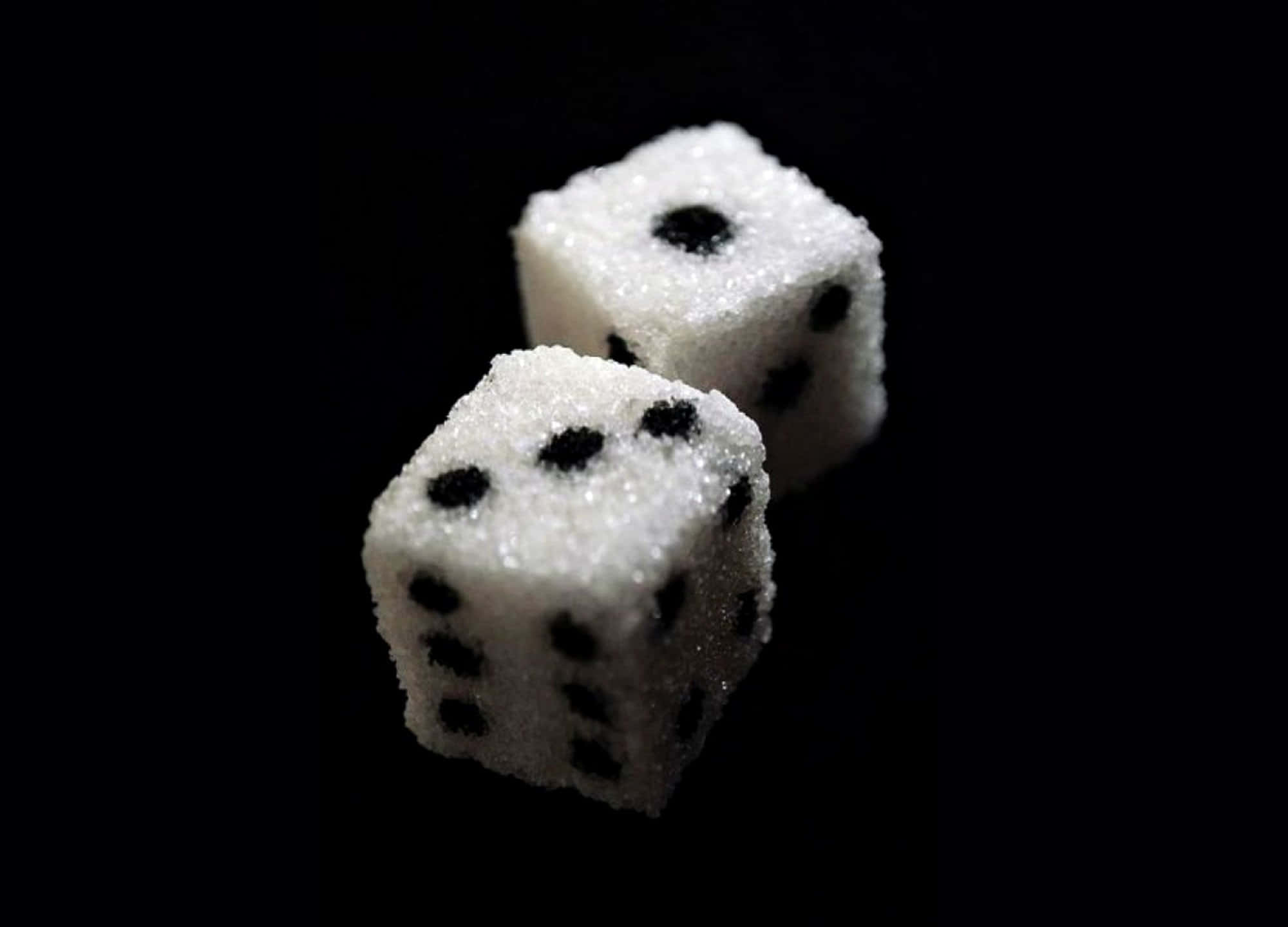 Black And White Dots 桌布 壁紙 — 兩顆骰子形狀的方糖，上面有黑色點點，放在純黑背景上。
