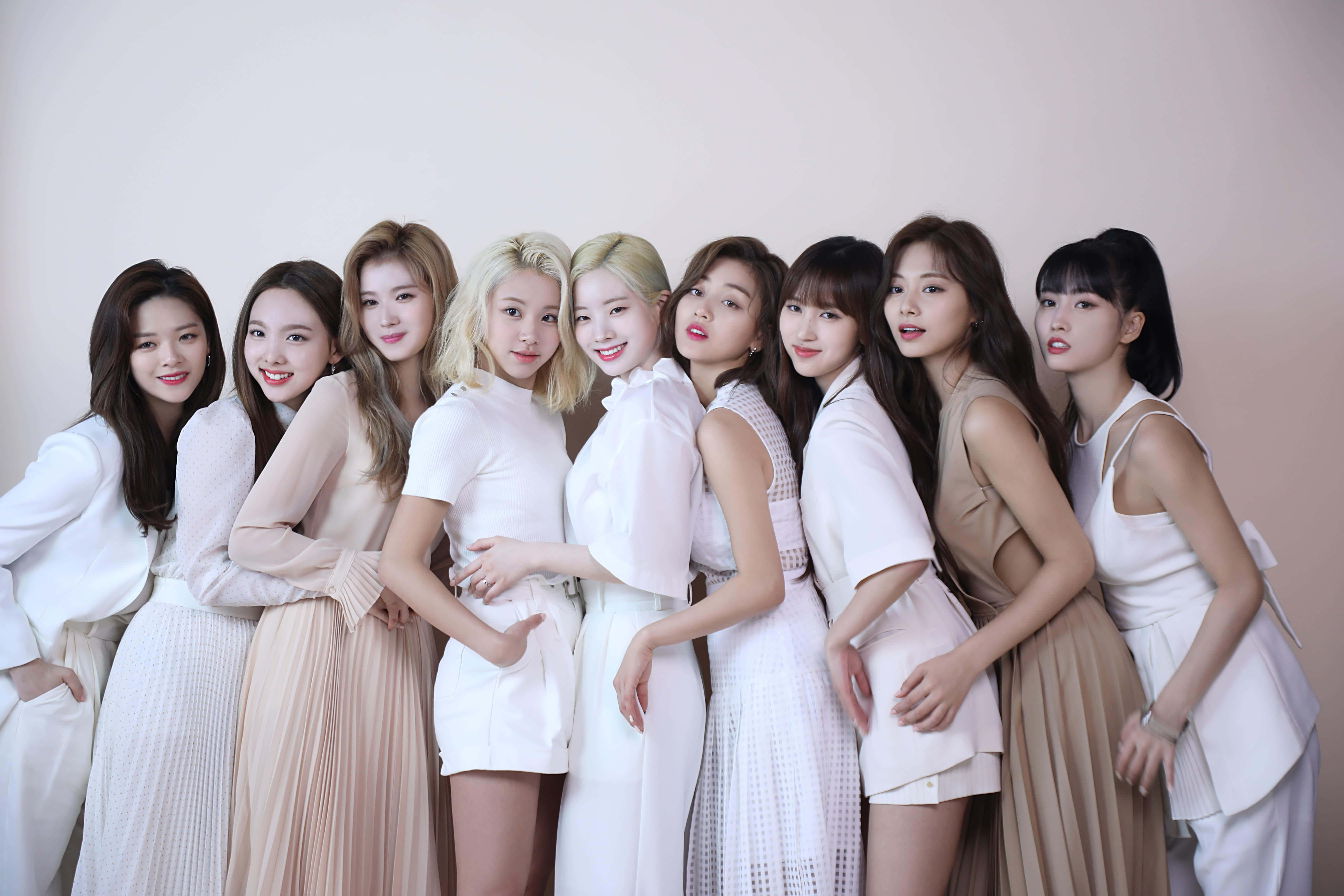 twice 桌布 壁紙 — 八位時尚女性身穿白色和米色服裝，在柔和的粉紅色背景前緊密地擺姿勢。