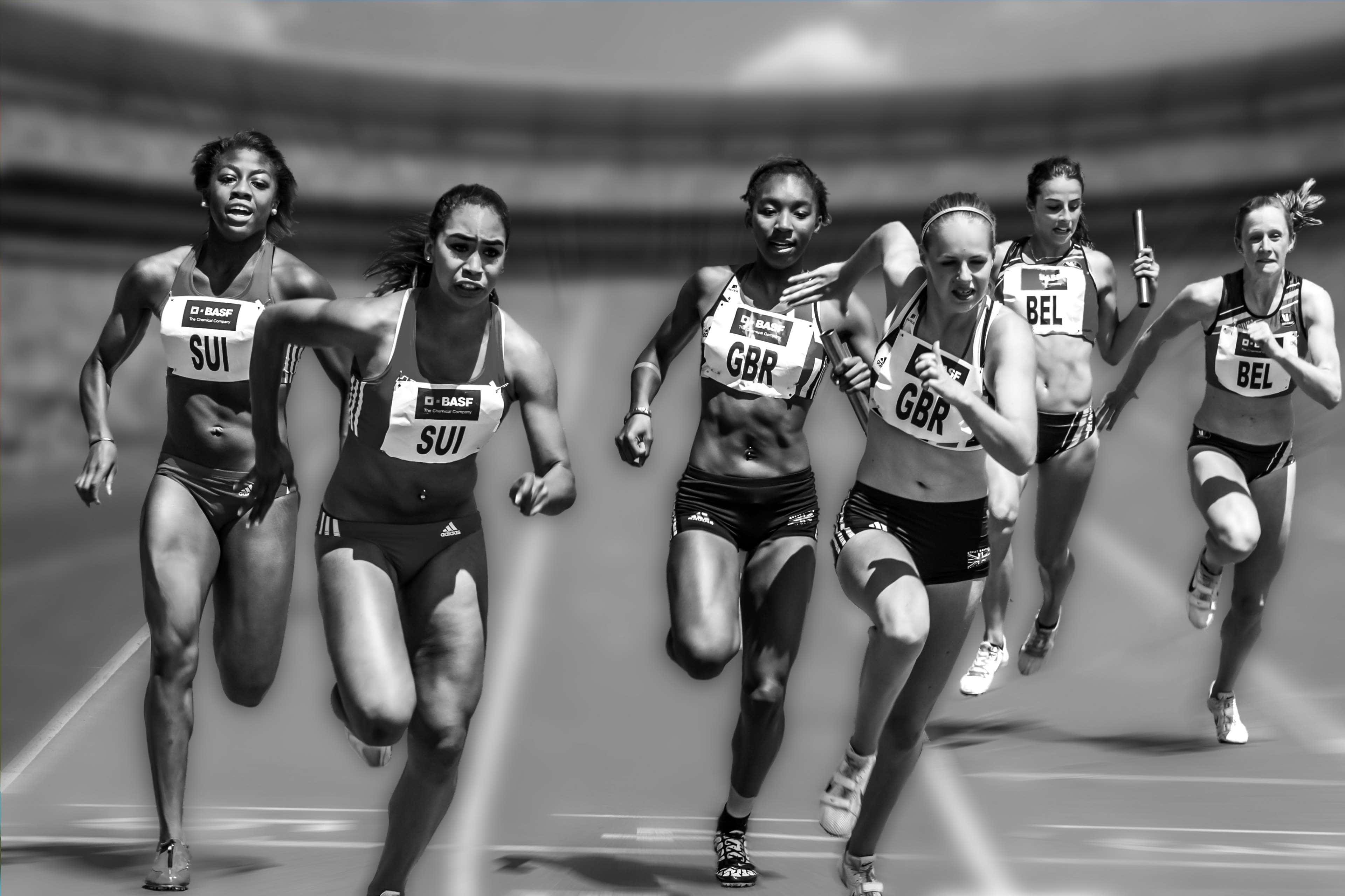 運動 桌布 壁紙 — 六位女運動員在黑白賽道上衝刺，動態模糊強調速度與競爭。