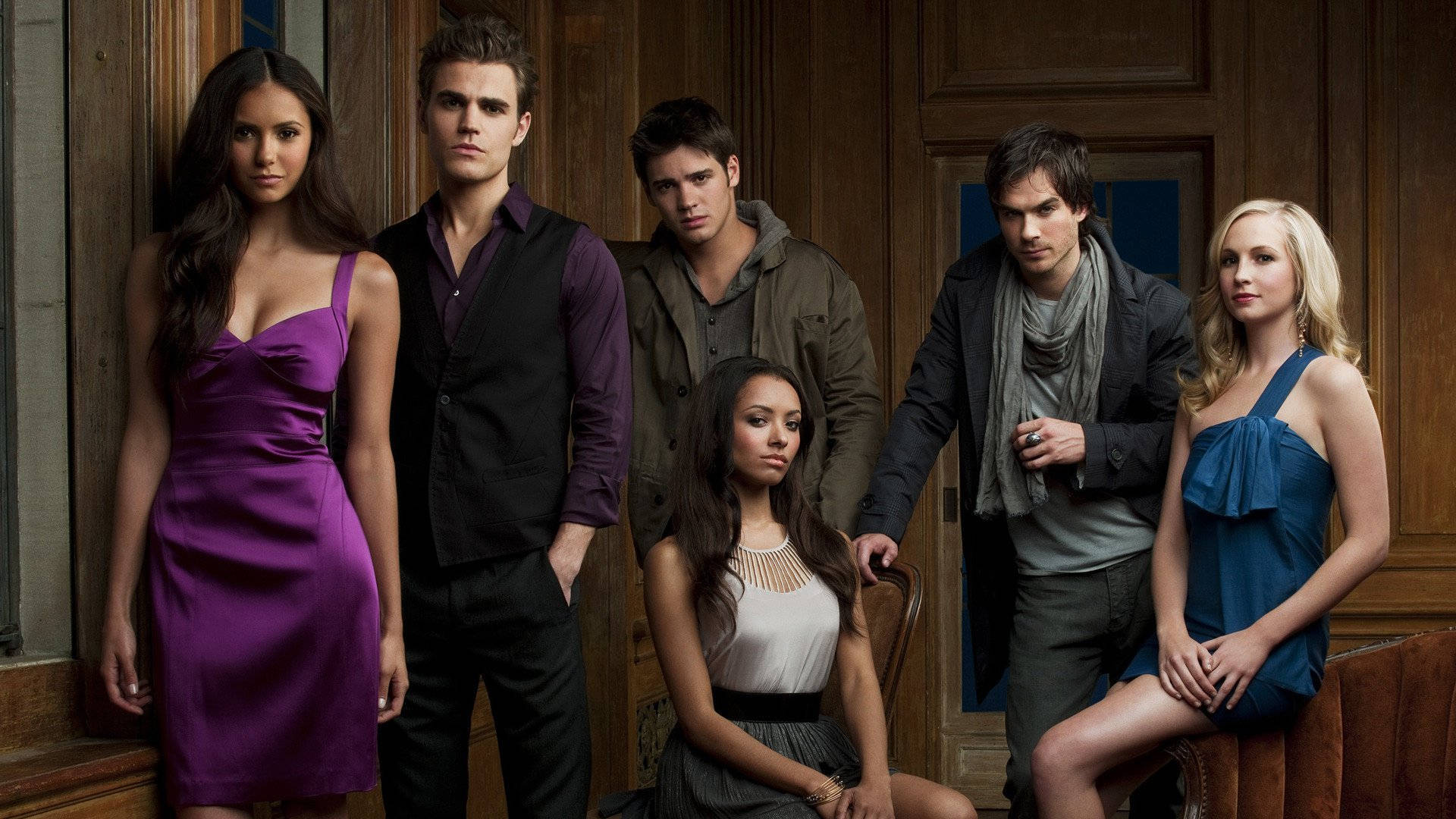 The Vampire Diaries 桌布 壁紙 — 六位年輕成年人穿著時尚服裝，在豐富的木質室內環境中戲劇性地擺姿勢，表情嚴肅。