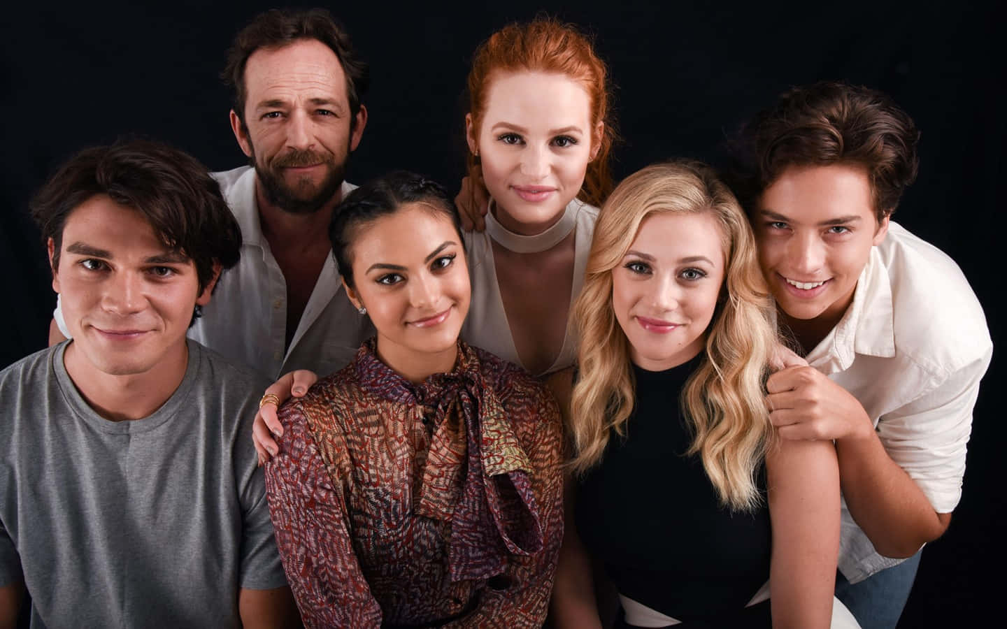 Riverdale 桌布 壁紙 — 六位微笑的演員在黑色背景前緊密地擺姿勢拍攝工作室肖像。