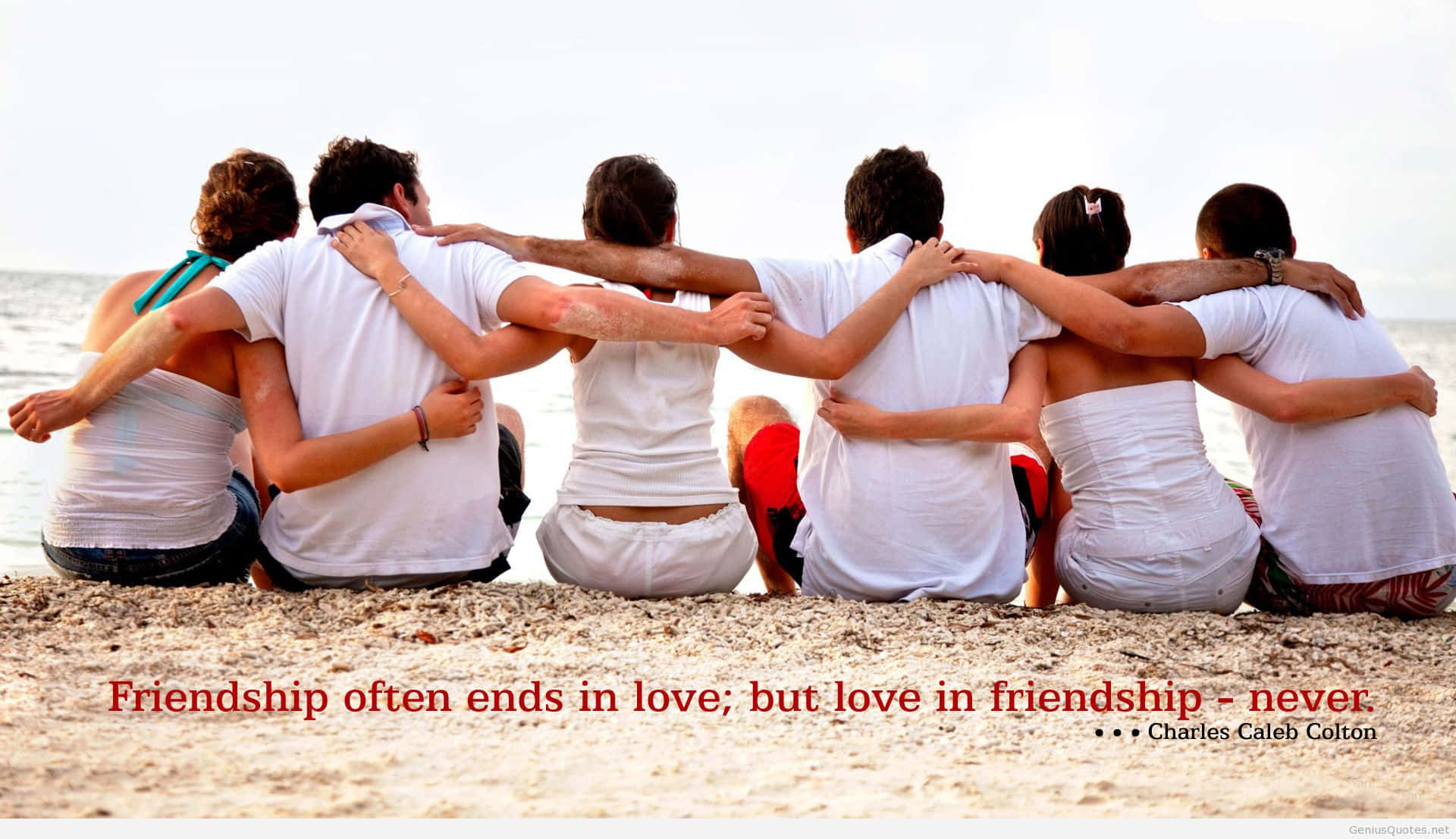 Friendship 桌布 壁紙 — 六位朋友背對背坐在沙灘上，手臂相連，面向海洋，天空明亮。