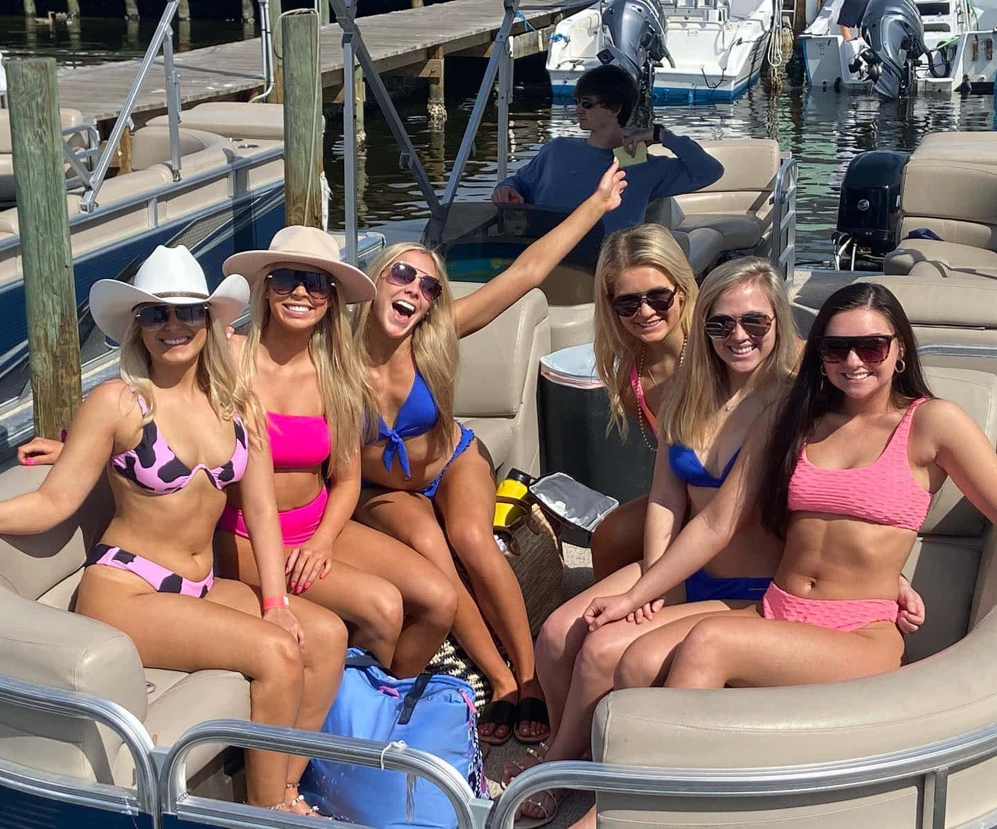 Crab Island 桌布 壁紙 — 六位笑容滿面的女士穿著色彩繽紛的比基尼，在停泊於陽光普照的碼頭的浮橋船上愉快地擺姿勢。