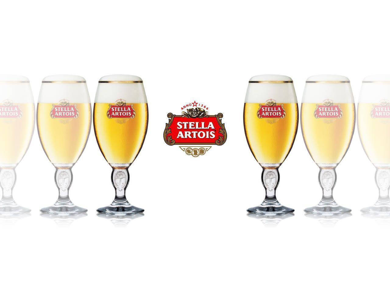Drink 桌布 壁紙 — 六個 Stella Artois 啤酒杯裝滿金色啤酒和白色泡沫，對稱地排列在品牌標誌周圍，背景為潔白。