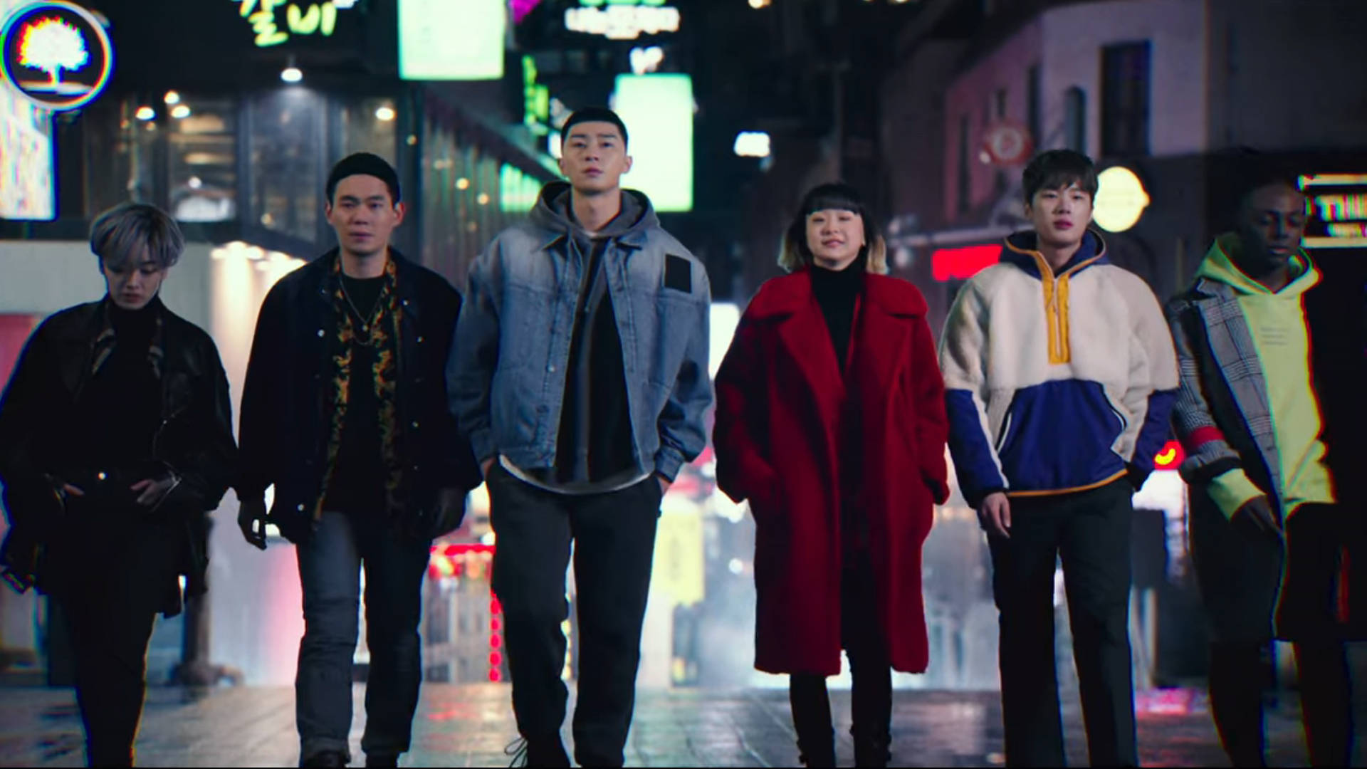 drama 桌布 壁紙 — 六個不同背景的年輕人自信地走在夜晚霓虹燈照亮的城市街道上，發光的招牌倒映在濕漉漉的路面上。