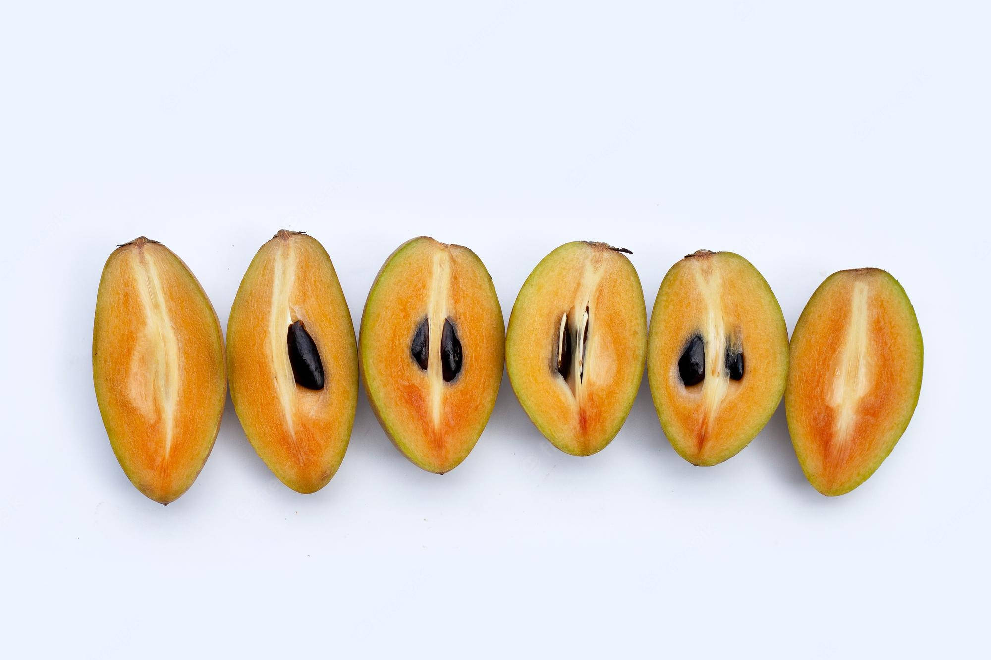 Fruits 桌布 壁紙 — 六個切半的山竹排列成一排，在白色背景上露出多汁的果肉和黑色的種子。