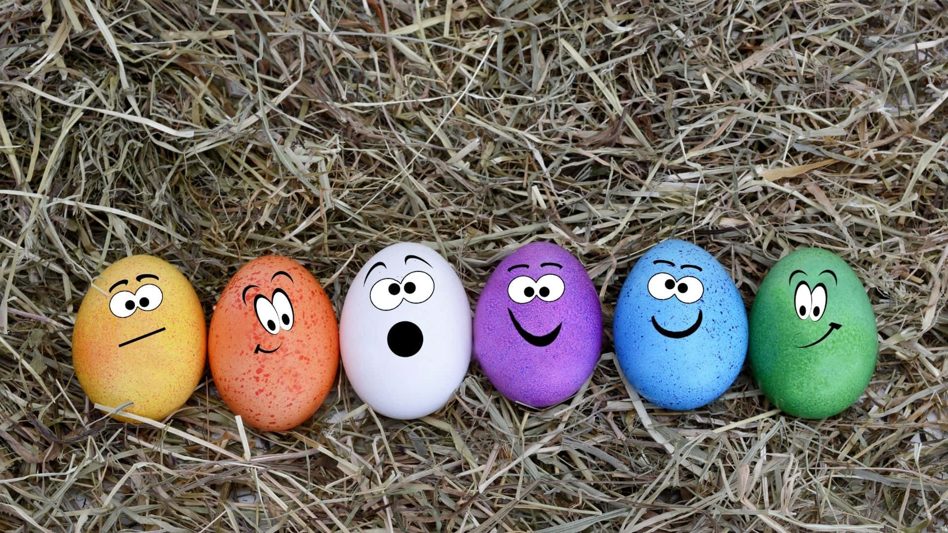 Easter Egg 桌布 壁紙 — 六個色彩繽紛的彩繪雞蛋，帶有卡通臉孔，排成一排放在乾草上，每個都展現獨特的表情。