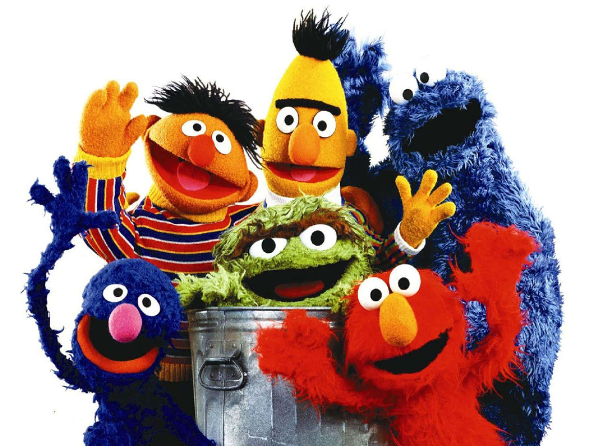 Sesame Street 桌布 壁紙 — 六個色彩繽紛的芝麻街布偶在白色背景前開心地圍著一個金屬桶。