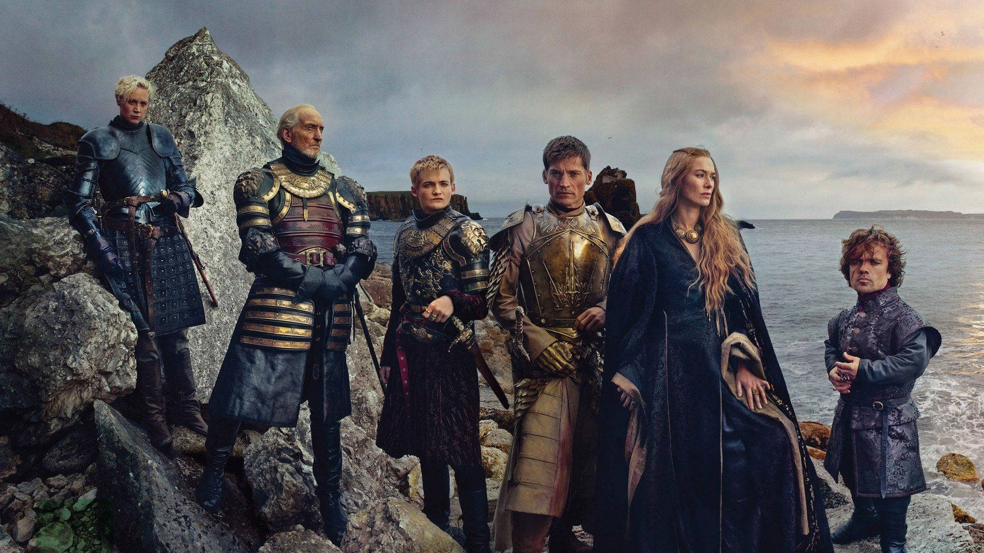 House Lannister 桌布 壁紙 — 六個身穿盔甲的奇幻角色在日落時分莊嚴地站在岩石懸崖上，俯瞰著波濤洶湧的大海。
