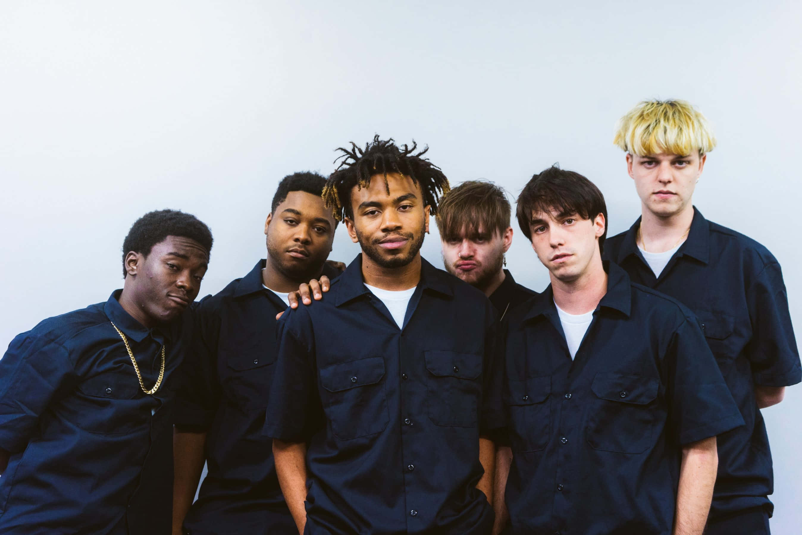 Brockhampton 桌布 壁紙 — 六名身穿深藍色襯衫的男子在純白背景前自信地擺出嚴肅的表情。