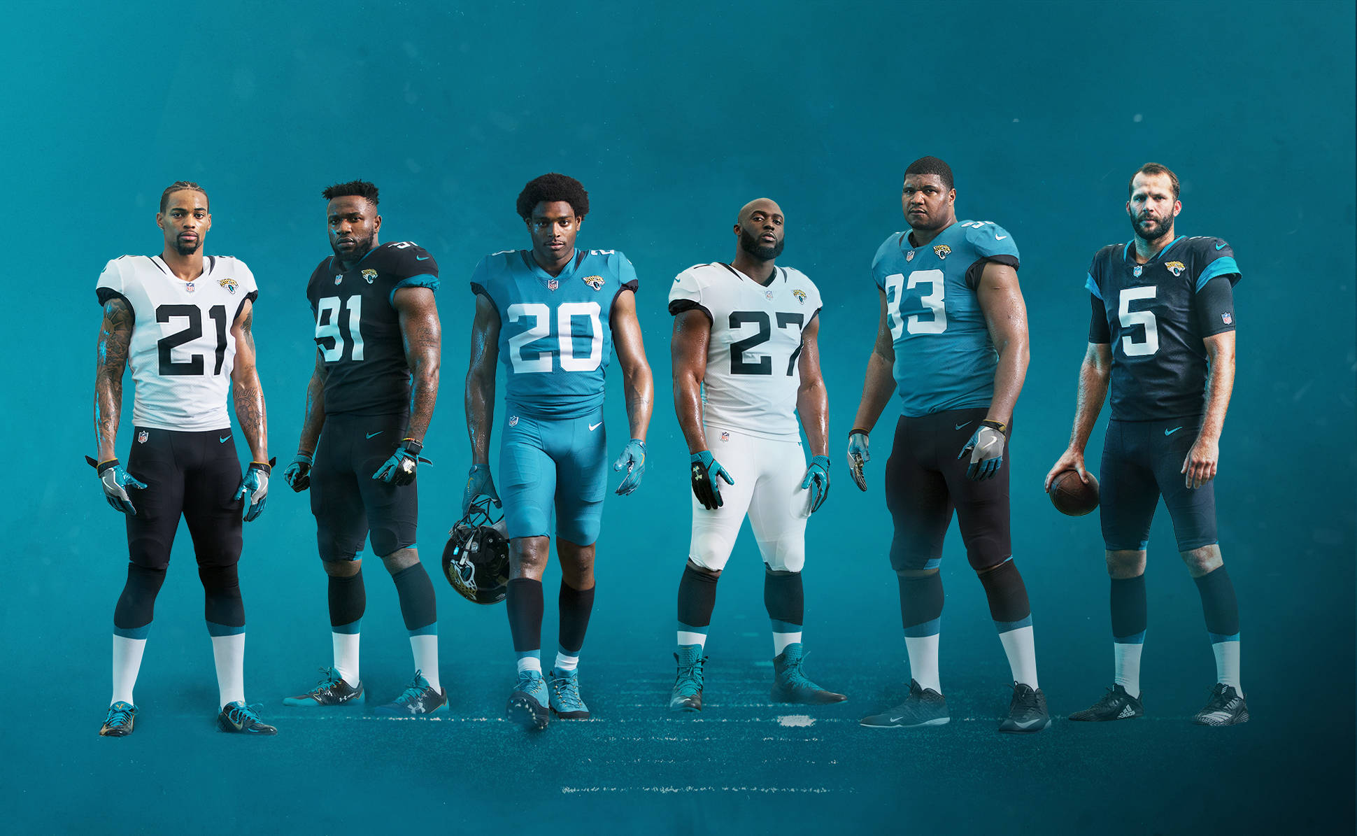 Jaguars 桌布 壁紙 — 六名身穿球隊制服的傑克遜維爾美洲虎足球員在純色青綠色攝影棚背景前自信地站立。