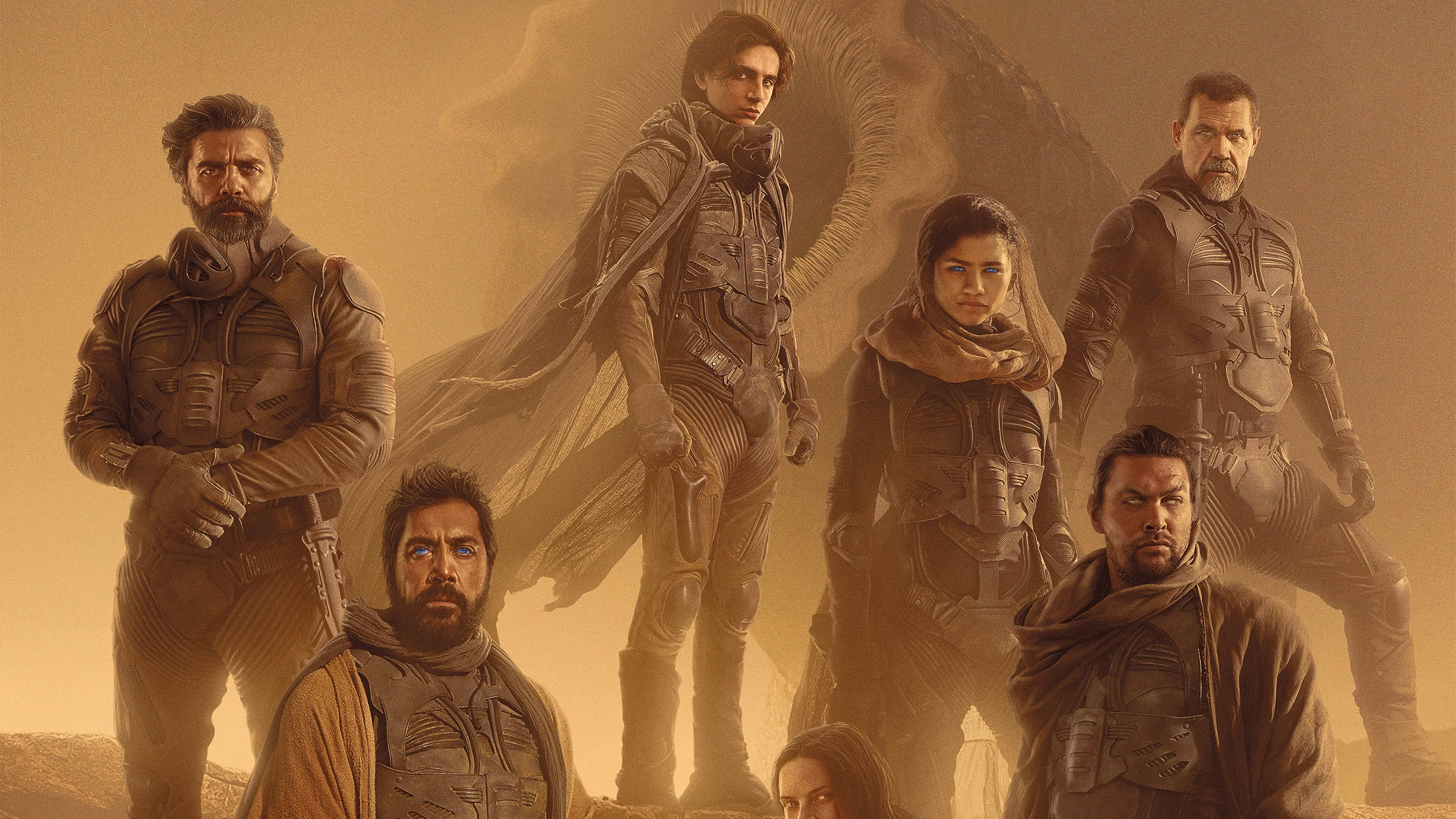 Dune 2021 桌布 壁紙 — 六名身穿裝甲的粗獷太空旅行者，在旋轉的橙色沙漠背景下，面對著身後若隱若現的巨大外星生物，毫不畏懼地站立著。