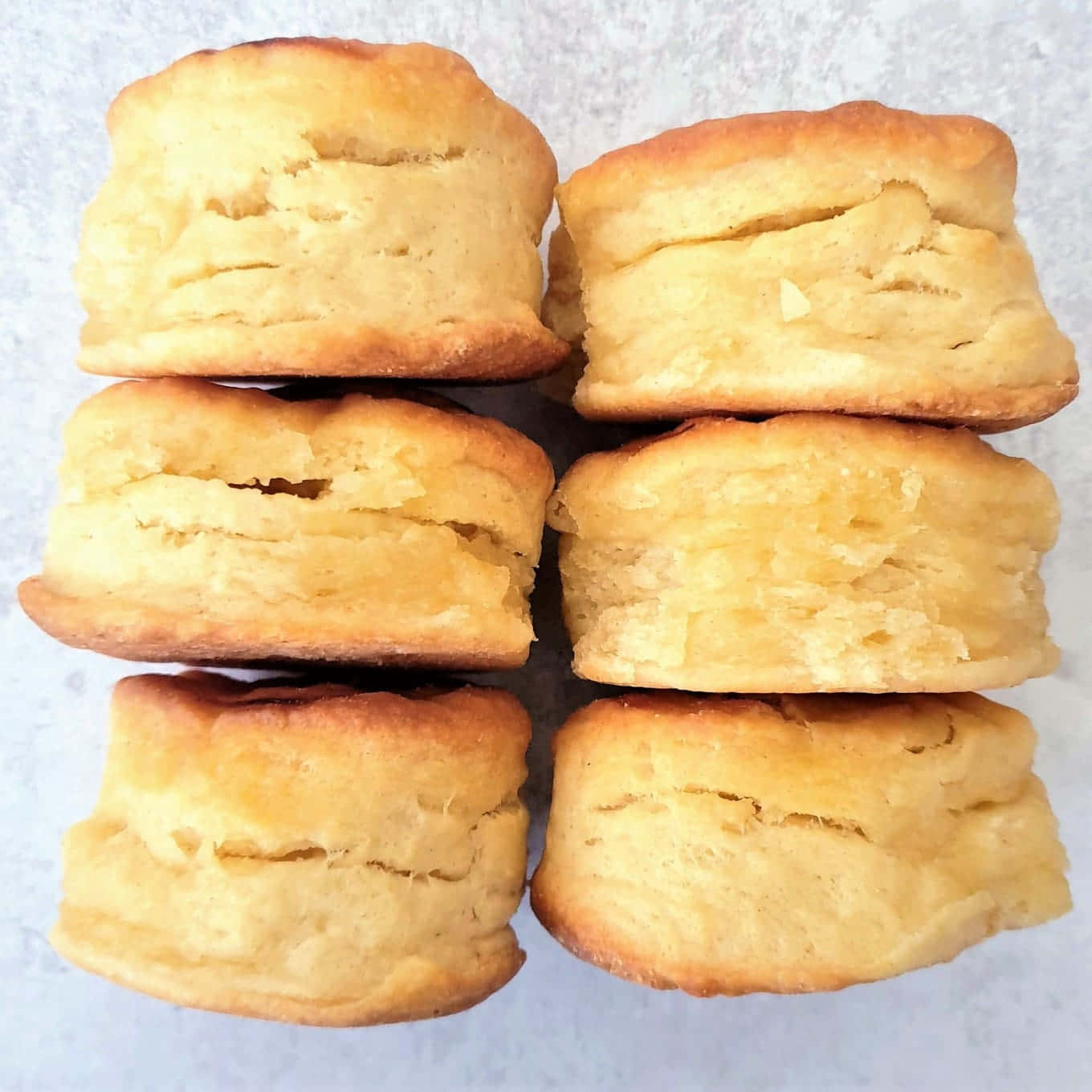 Biscuit 桌布 壁紙 — 六塊金黃色的自製餅乾排列成兩列，放在淺灰色表面上。
