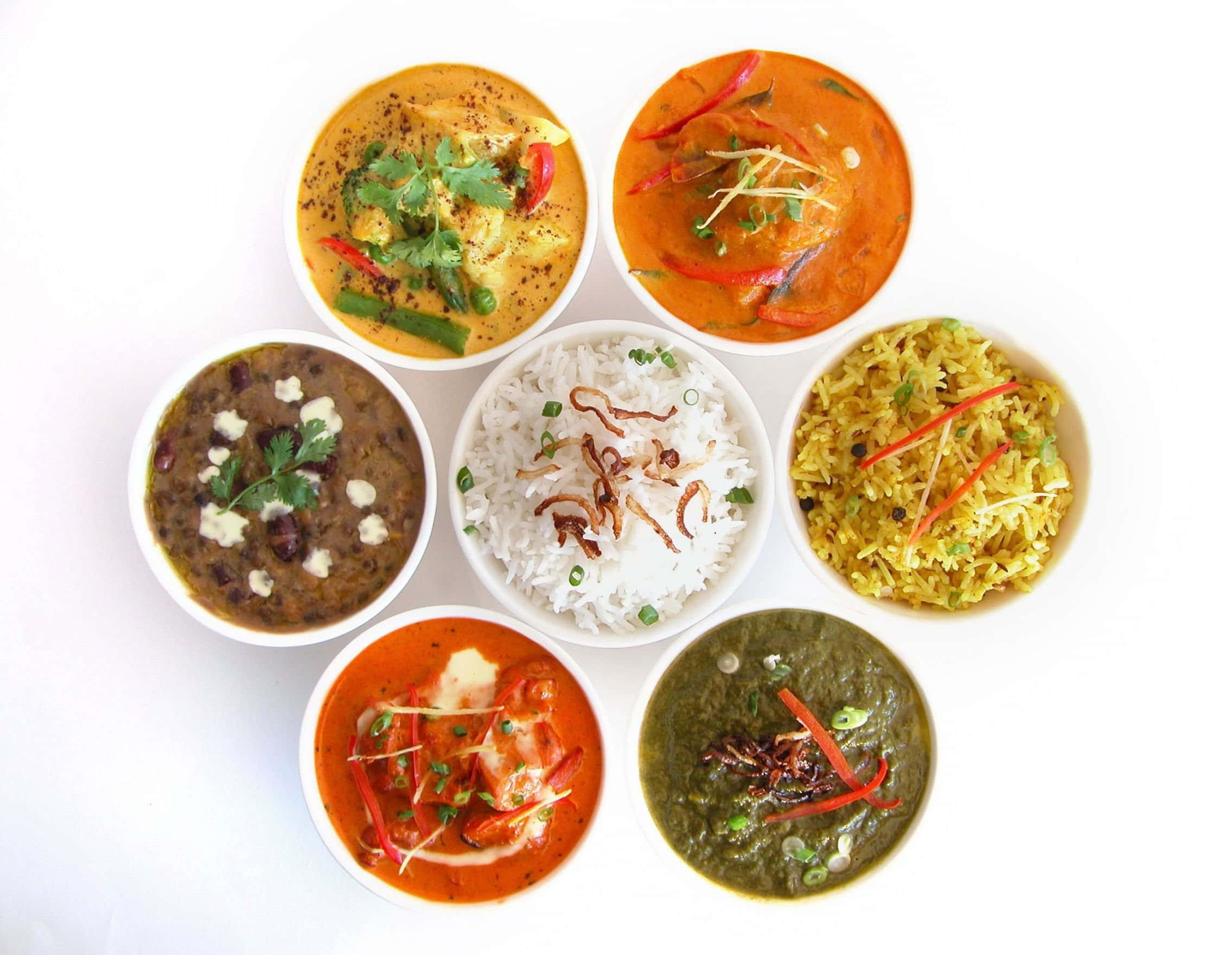 Indian 桌布 壁紙 — 六碗色彩繽紛的印度咖哩和米飯在白色背景上排列成圓形。