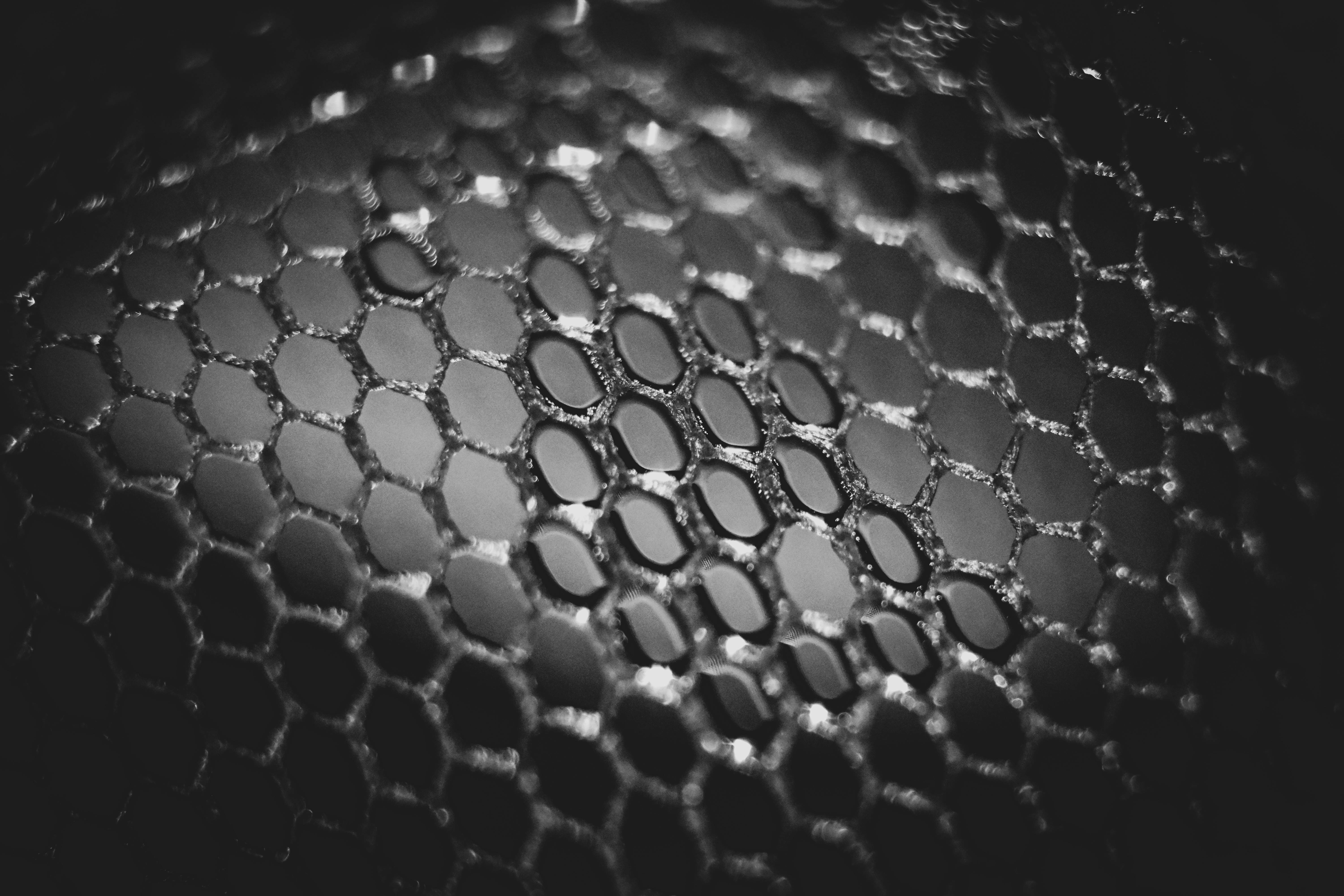 Honeycomb 桌布 壁紙 — 六角形網格紋理的近距離單色拍攝，淺景深和戲劇性照明。