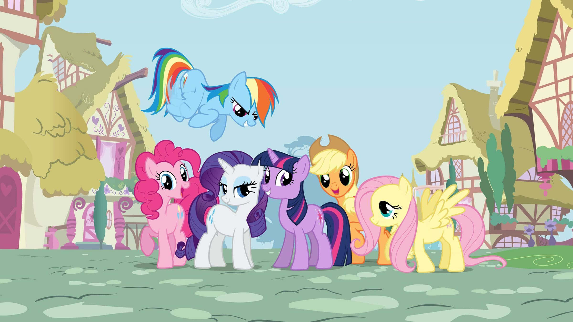 pony 桌布 壁紙 — 六隻色彩繽紛的卡通小馬一起站在一個奇幻村莊，有一隻彩虹鬃毛的小馬在上方飛翔。
