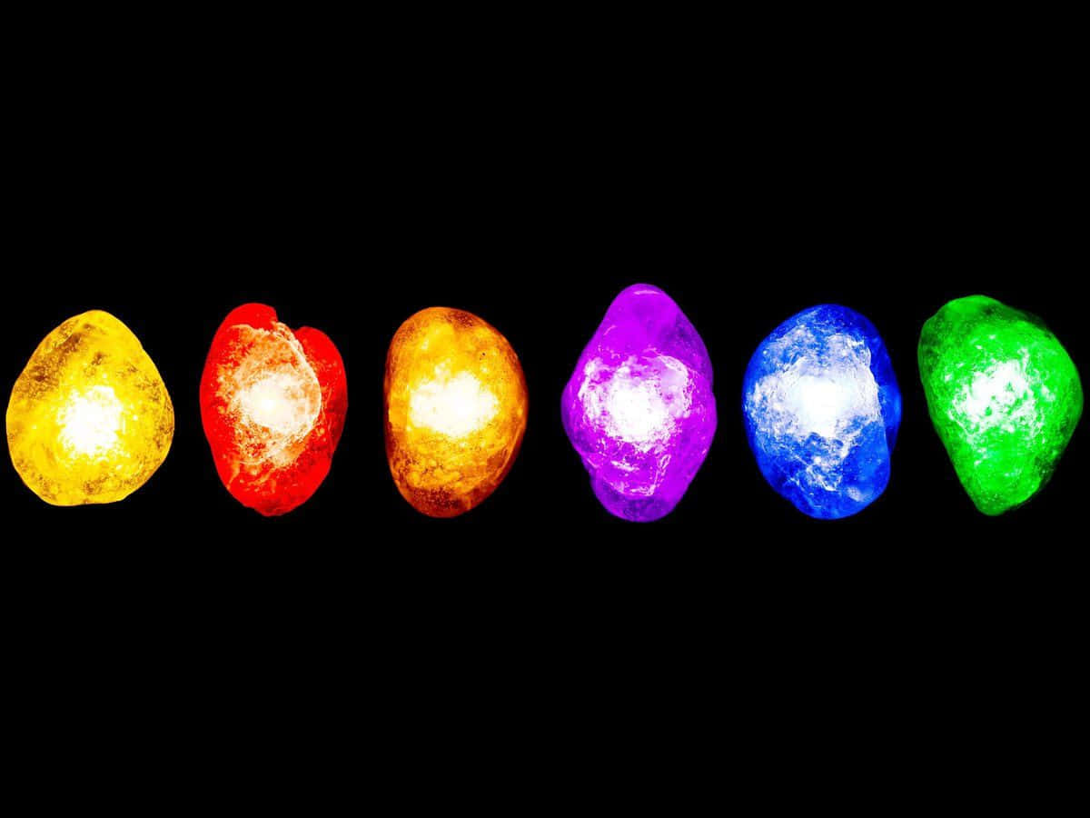 Reality Stone 桌布 壁紙 — 六顆發光的宇宙寶石在漆黑虛空中散發出鮮豔色彩，每顆都閃爍著內在光芒。