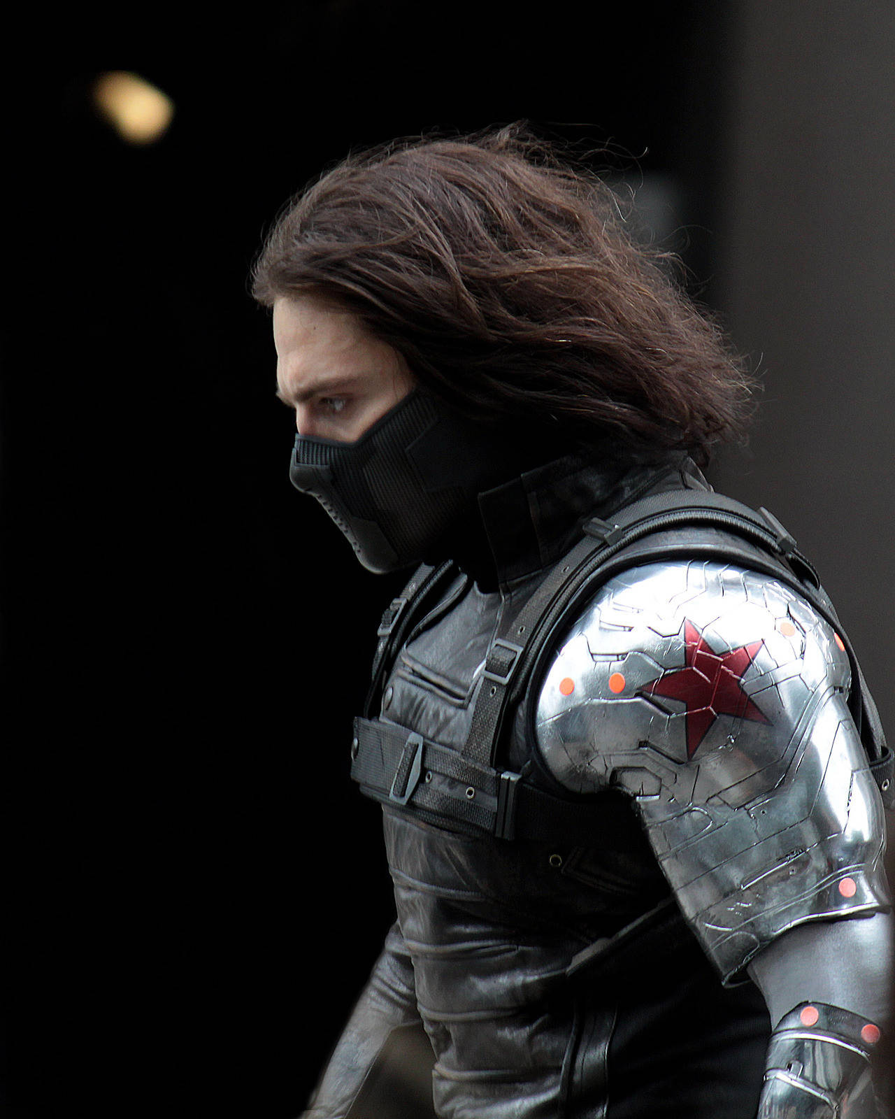 Bucky Barnes 桌布 壁紙 — 冬日戰士標誌性金屬手臂的特寫，帶有紅色星星標誌，背景為深色。