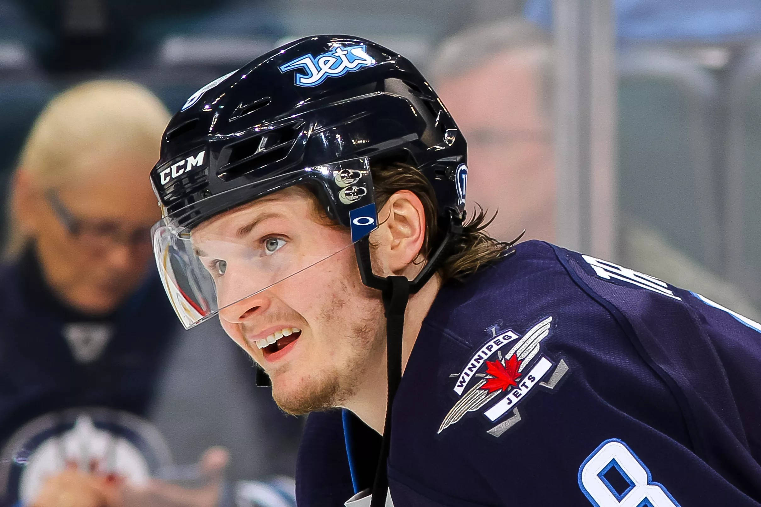 hockey 桌布 壁紙 — 冰上一位微笑的曲棍球運動員身穿溫尼伯噴射機隊球衣和頭盔的特寫。