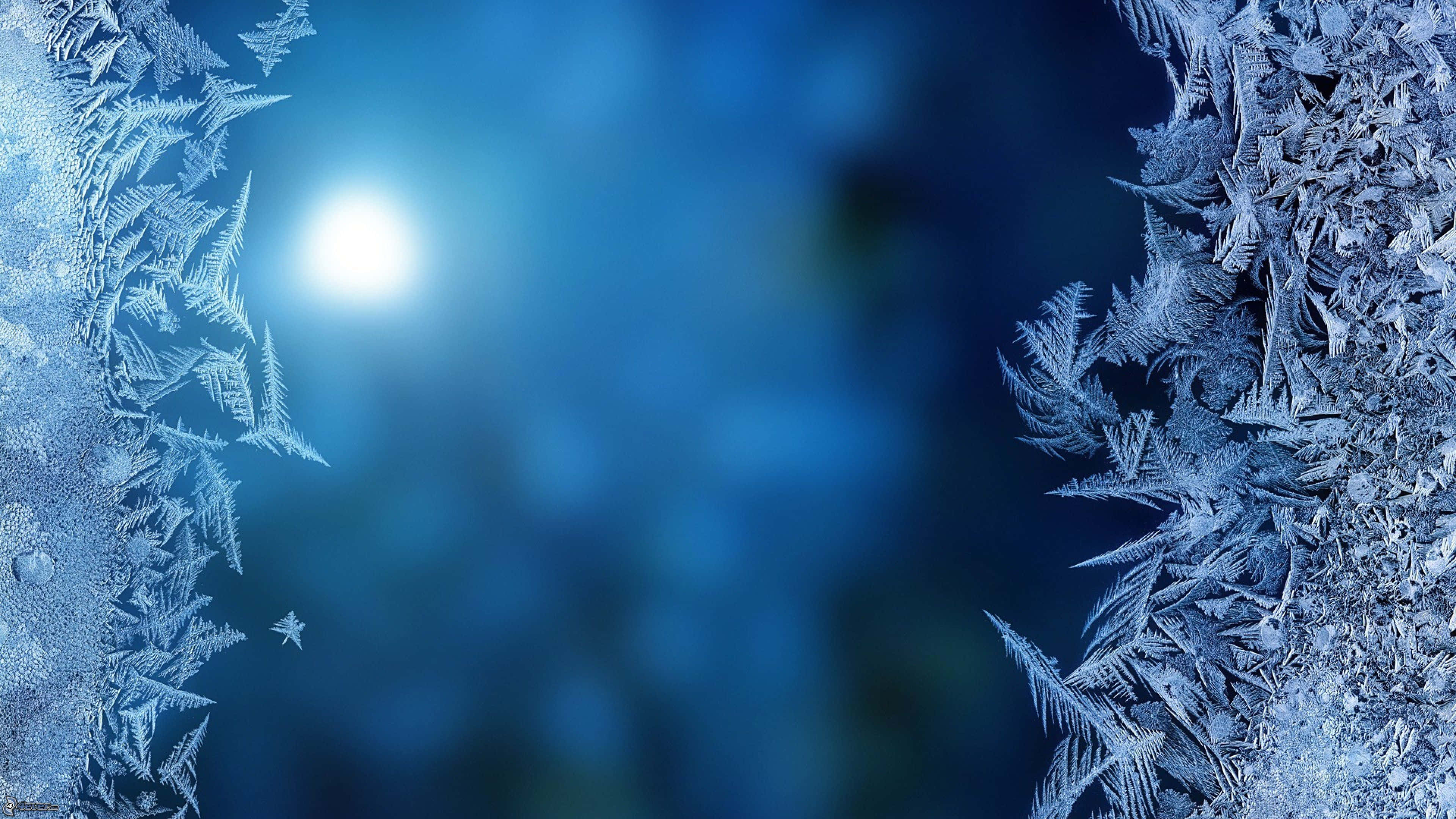 Frost 桌布 壁紙 — 冰冷的冰晶框住一輪發光的月亮，背景是深藍色模糊的。