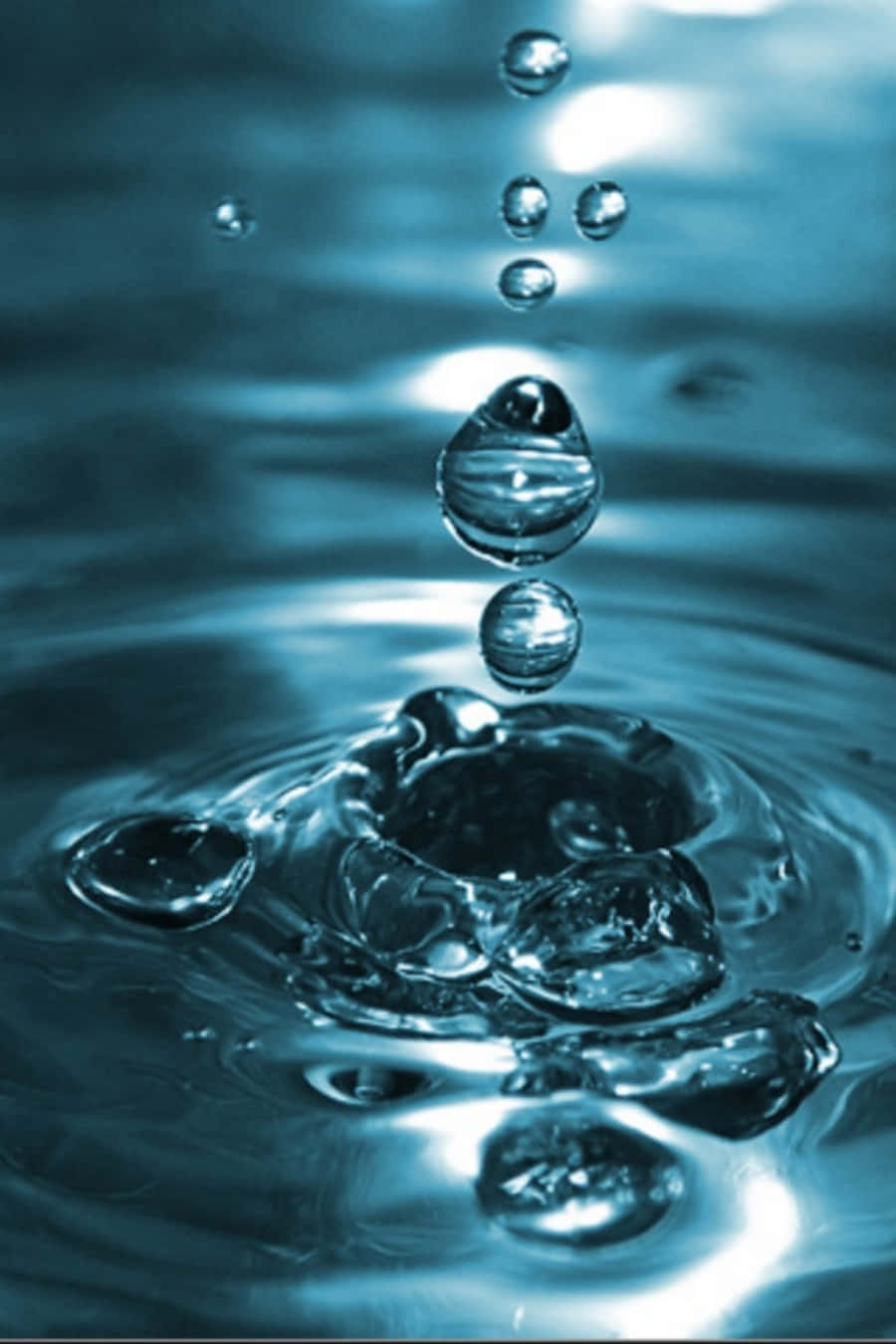 Water Drop 桌布 壁紙 — 冰凍一刻，水滴懸浮在泛起漣漪的水面上，呈現清涼的藍色調。