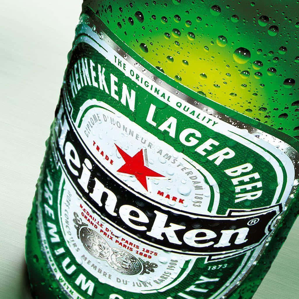 Heineken 桌布 壁紙 — 冰凍海尼根啤酒瓶的特寫，標誌性的綠色玻璃上閃爍著冷凝水珠。