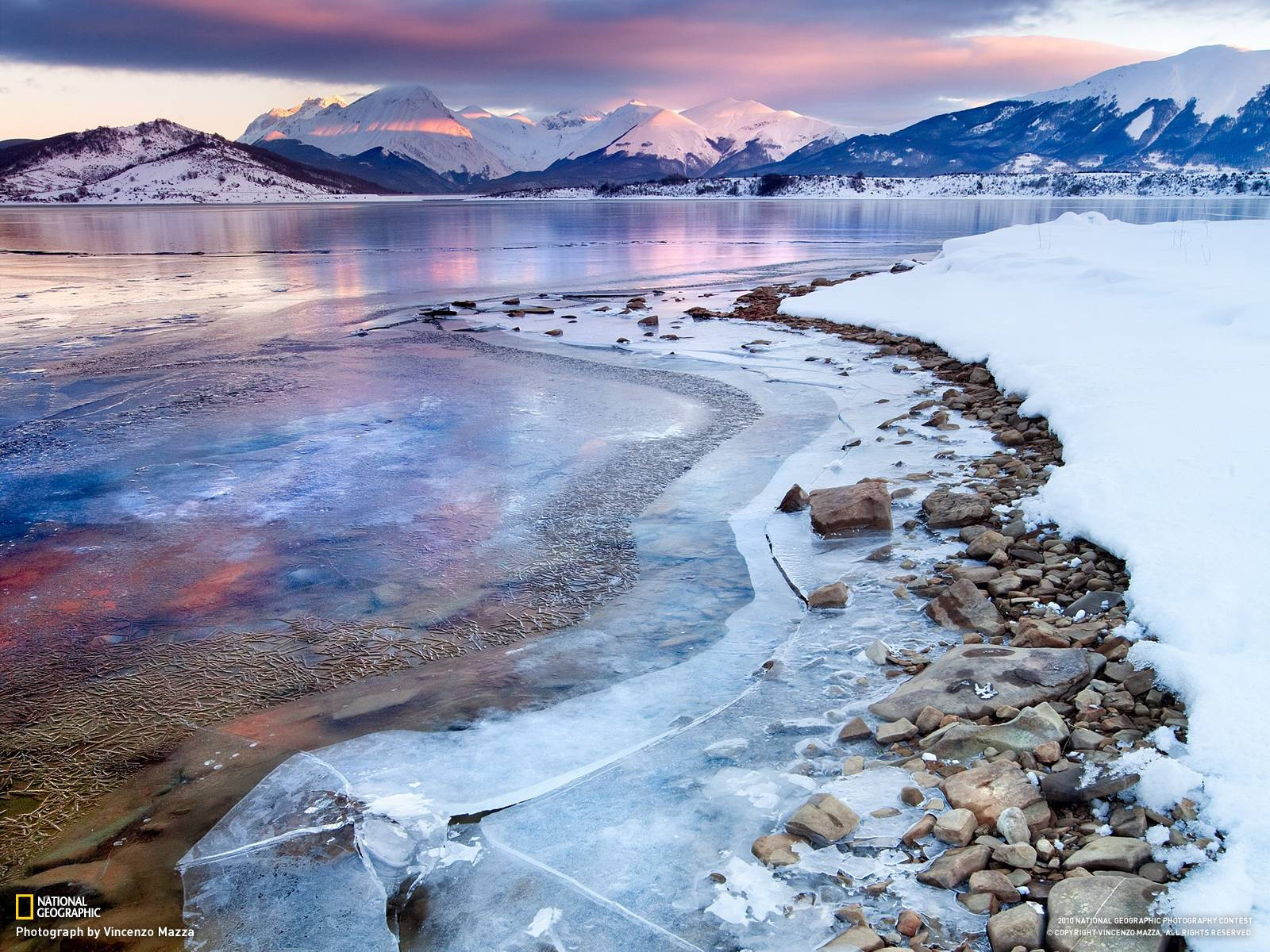 冰凍湖泊，雪覆岩石，遠處山脈，夕陽時分。 — 國家地理 壁紙