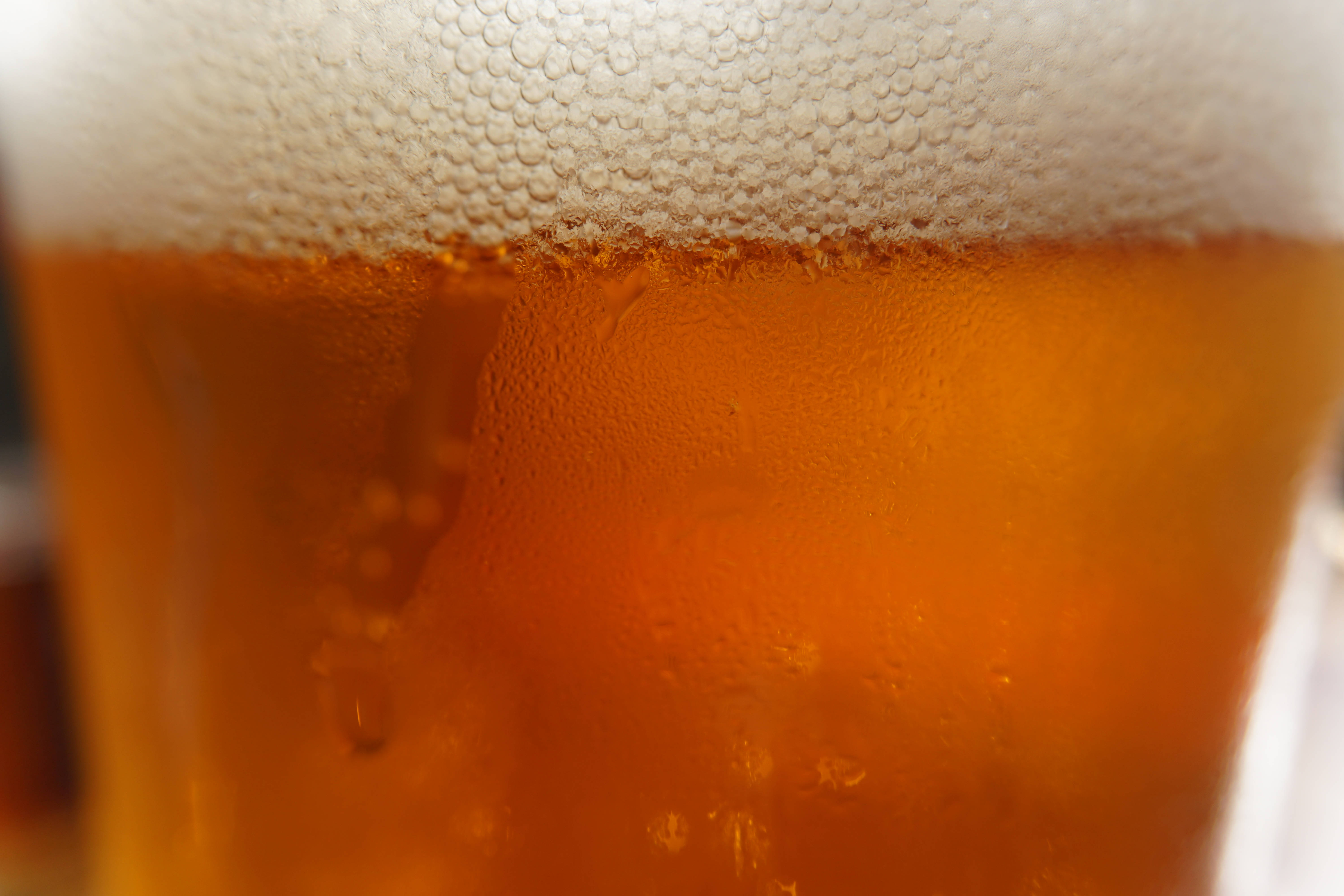 Beer 桌布 壁紙 — 冰凍琥珀色啤酒的特寫，帶有白色泡沫和玻璃杯上的冷凝水滴。