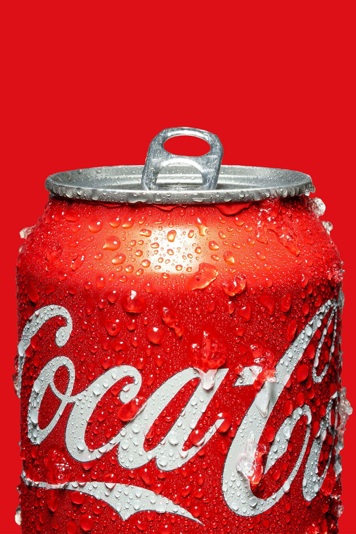 coca cola 桌布 壁紙 — 冰凍的可口可樂罐在鮮紅色背景上閃爍著冷凝水珠。