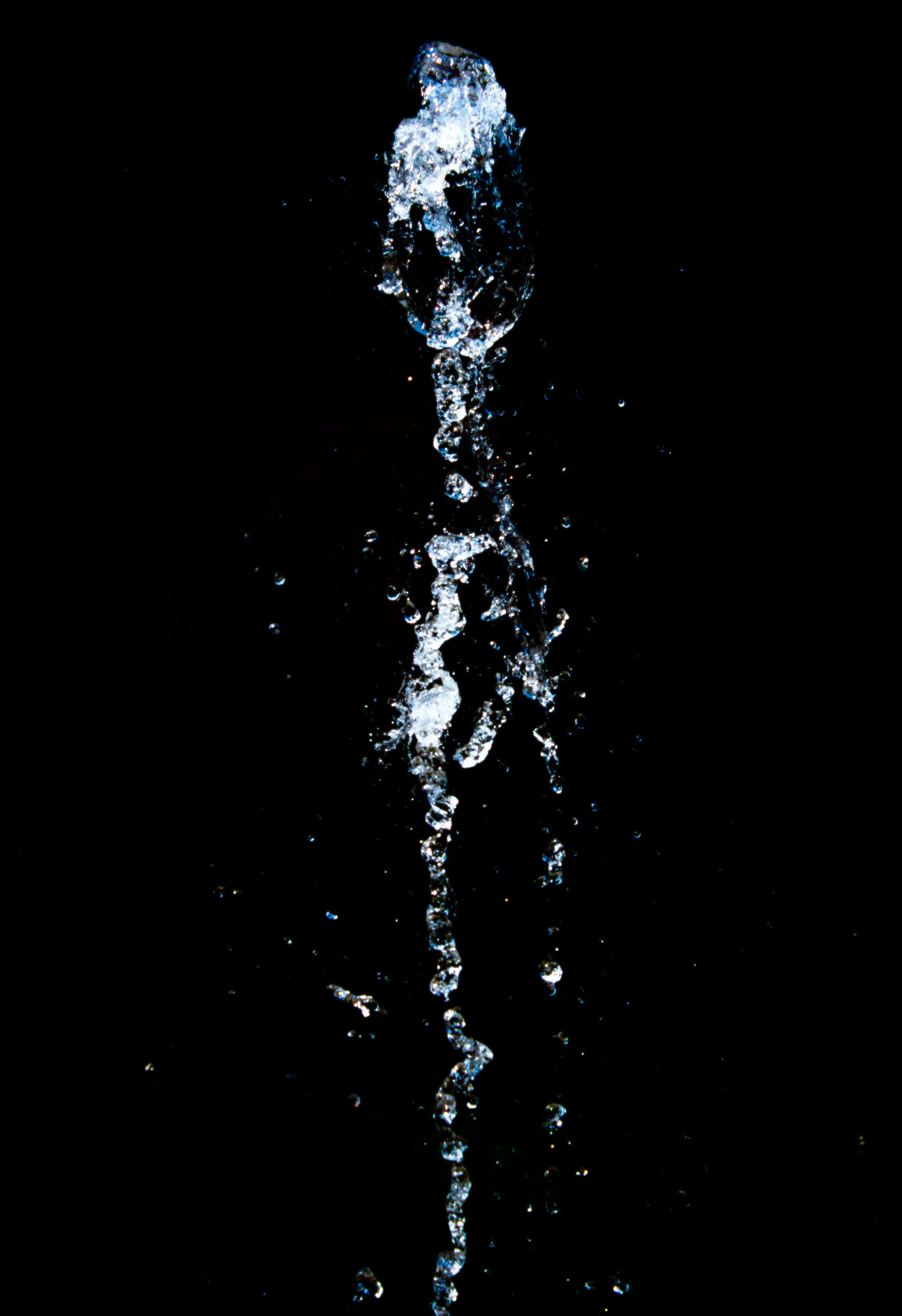 Splash 桌布 壁紙 — 冰凍的水花向上彎曲，映襯純黑背景，捕捉空中晶瑩的水滴。