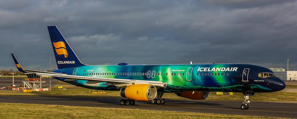 Plane 桌布 壁紙 — 冰島航空飛機帶有極光塗裝，在戲劇性的多雲天空下滑行。