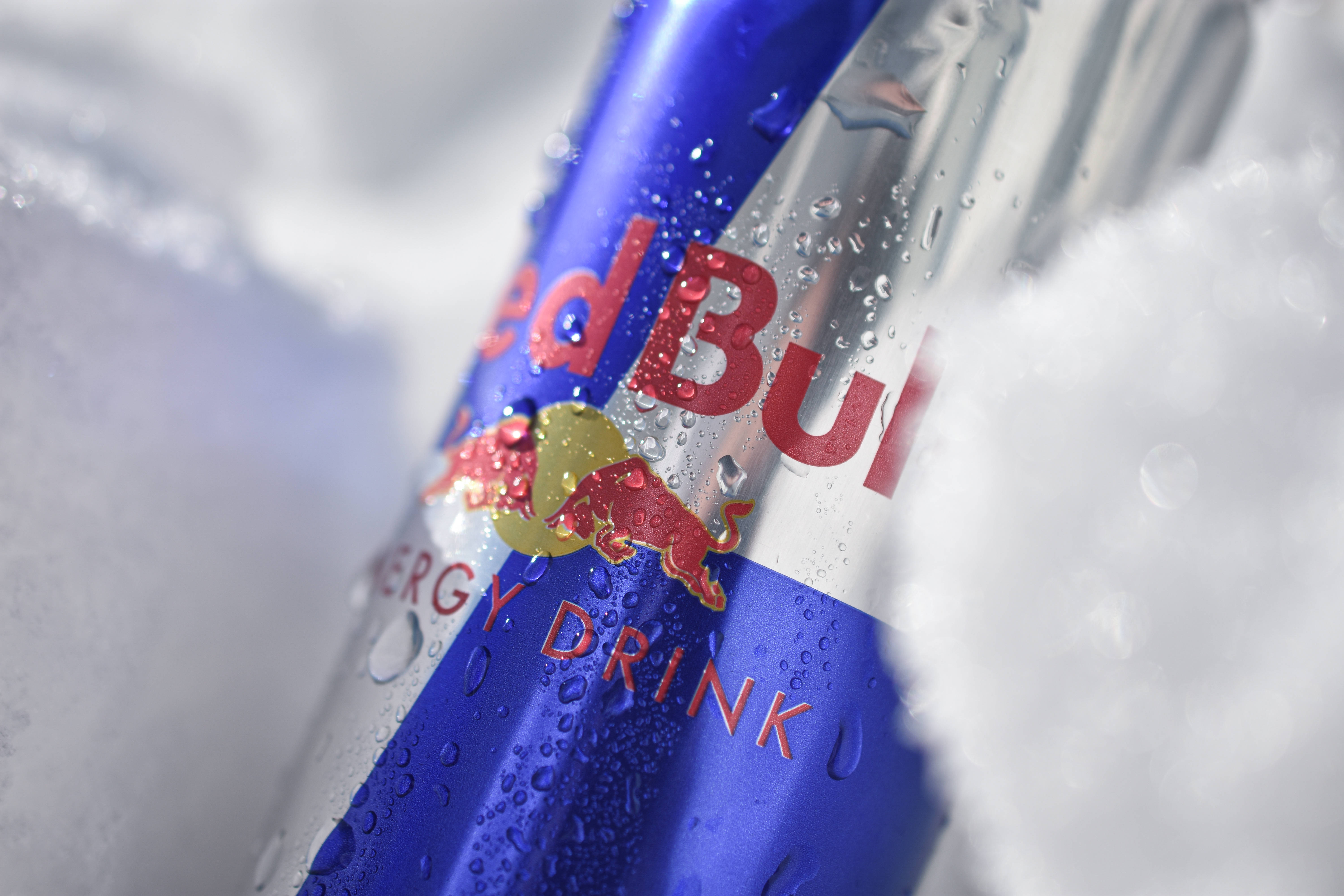 bull 桌布 壁紙 — 冰涼的Red Bull罐頭閃爍著冷凝水，依偎在蓬鬆的白冰中。