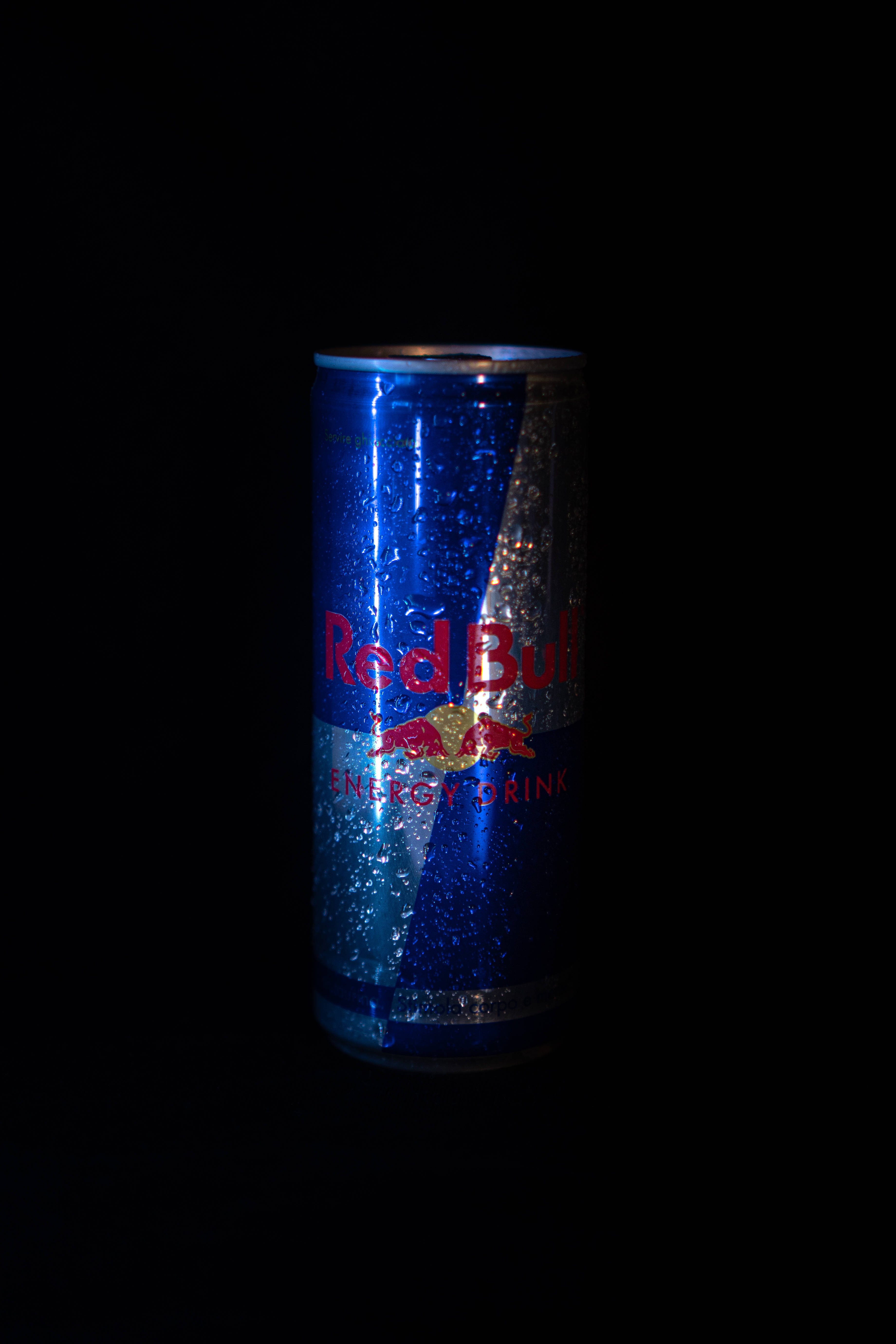 bull 桌布 壁紙 — 冰涼的Red Bull能量飲料罐在漆黑背景上閃爍著冷凝水珠。