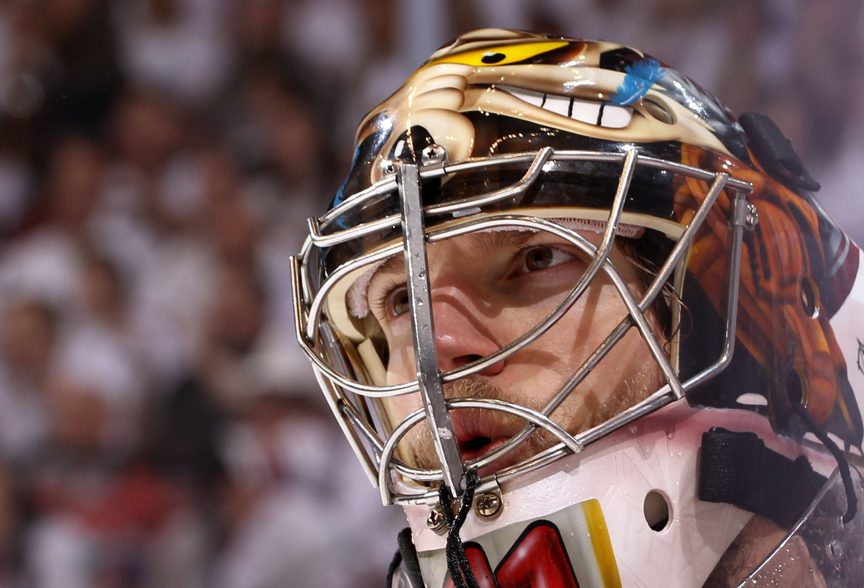 hockey 桌布 壁紙 — 冰球守門員在比賽中戴上兇猛老虎主題面具並專注表情的特寫。