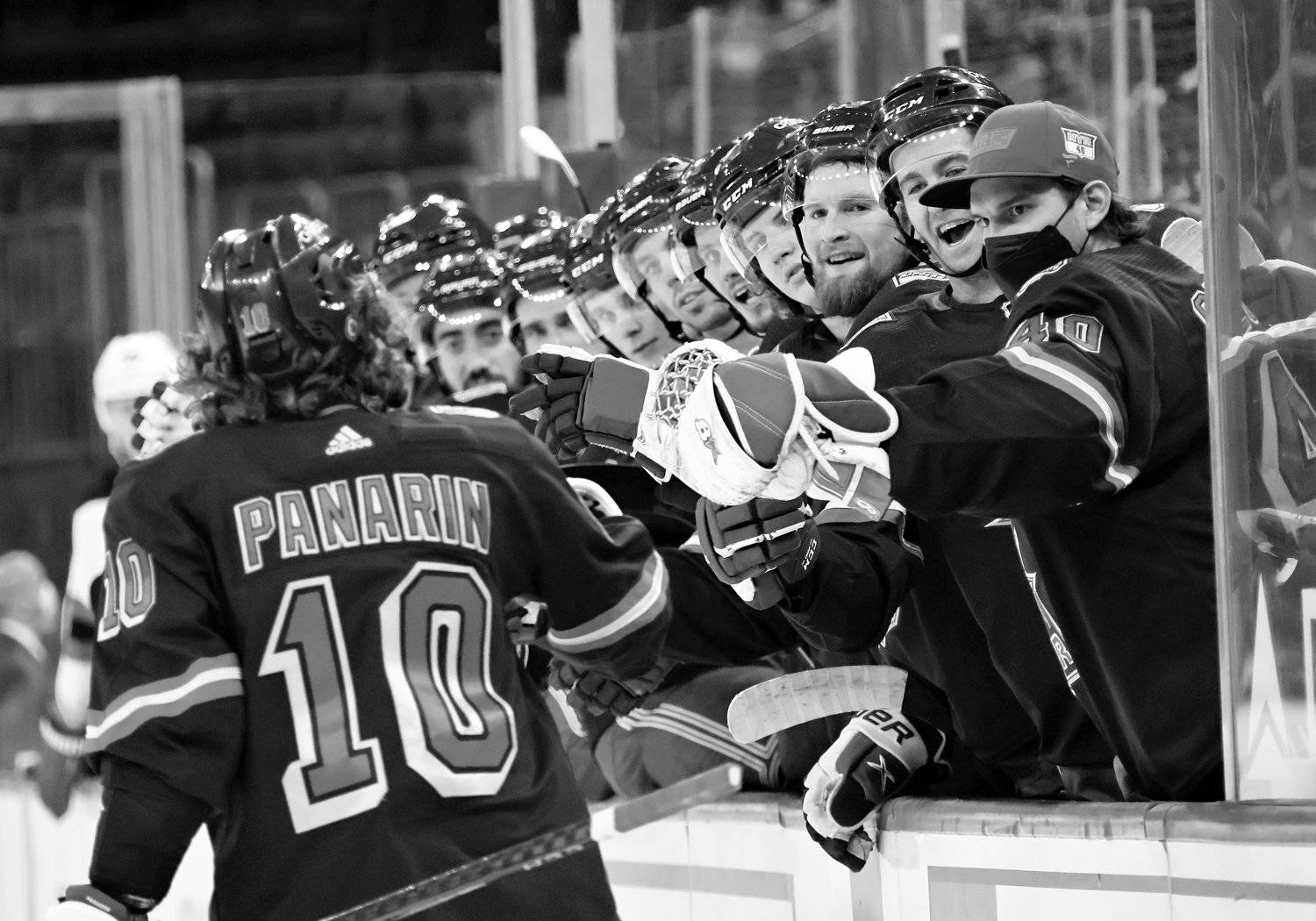 黑白 桌布 壁紙 — 冰球球員在板凳區慶祝的黑白照片，其中一名球員身穿10號球衣。