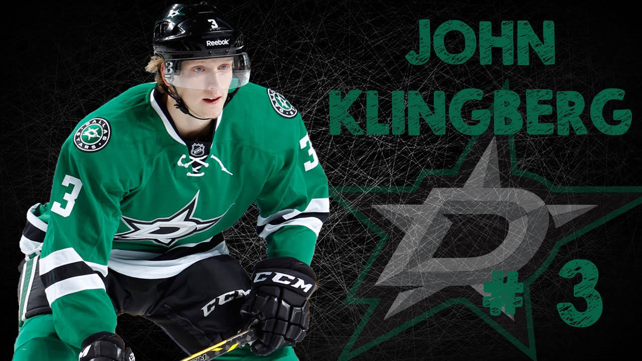 運動 桌布 壁紙 — 冰球運動員 John Klingberg 身穿綠色達拉斯星隊球衣，蹲伏在帶有球隊標誌的深色網狀背景前準備就緒。