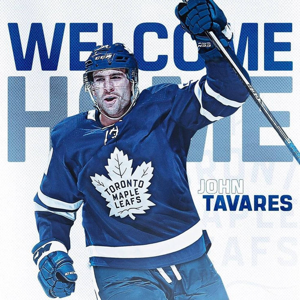 運動 桌布 壁紙 — 冰球運動員 John Tavares 身穿多倫多楓葉隊裝備，在鮮明的藍色歡迎回家背景前勝利地舉起球桿。