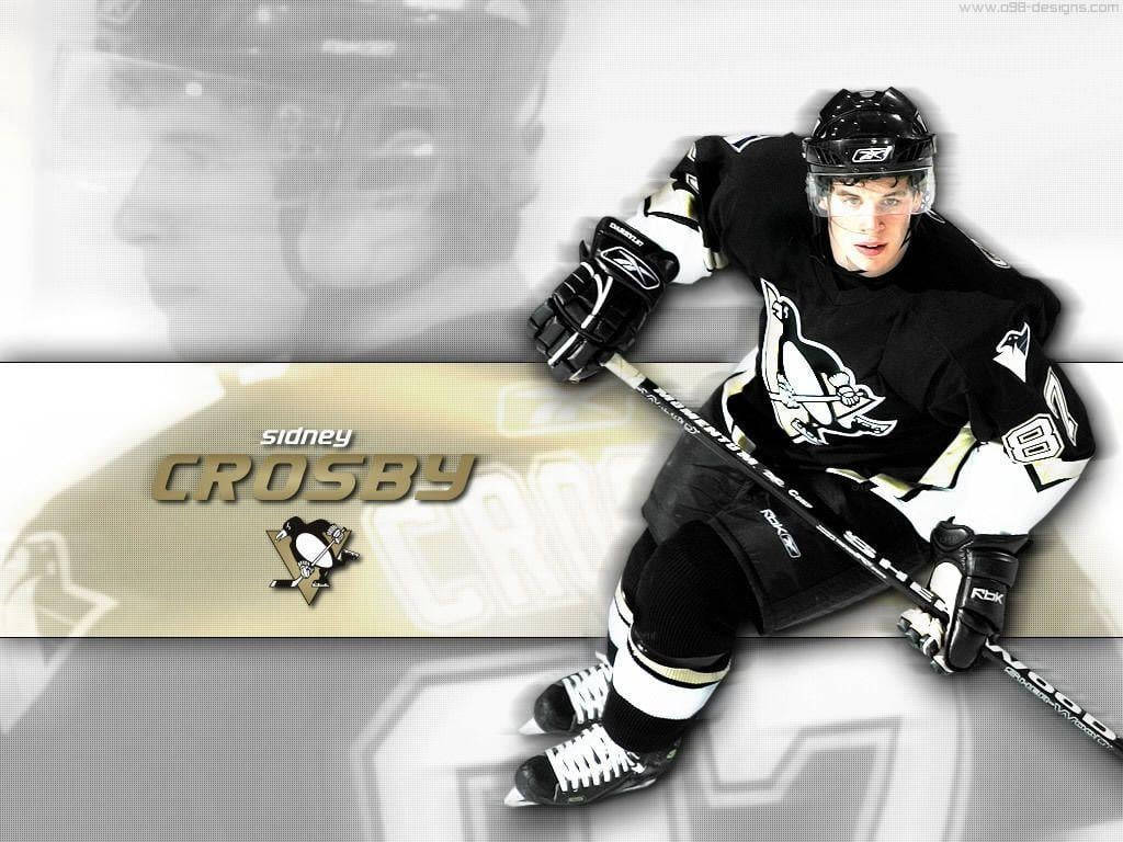 運動 桌布 壁紙 — 冰球運動員 Sidney Crosby 身穿黑金色制服，動態蹲下握著球棍，背景模糊，上面有他的名字和球隊標誌。