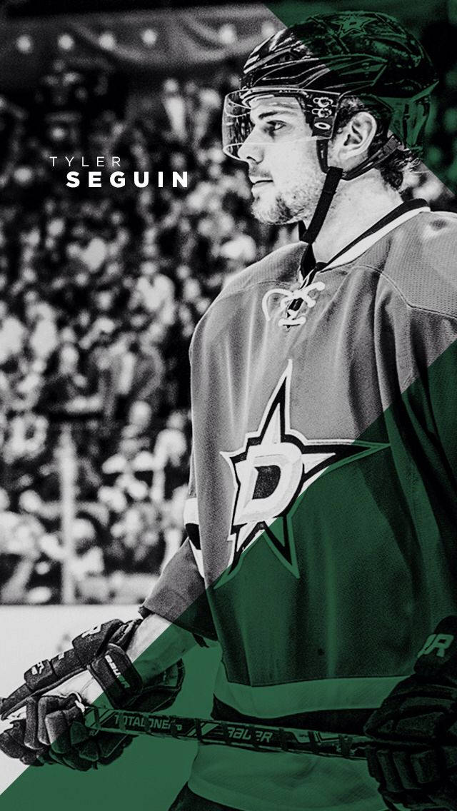 運動 桌布 壁紙 — 冰球運動員 Tyler Seguin 身穿達拉斯星隊裝備，專注地站在冰上，身後是模糊的人群。
