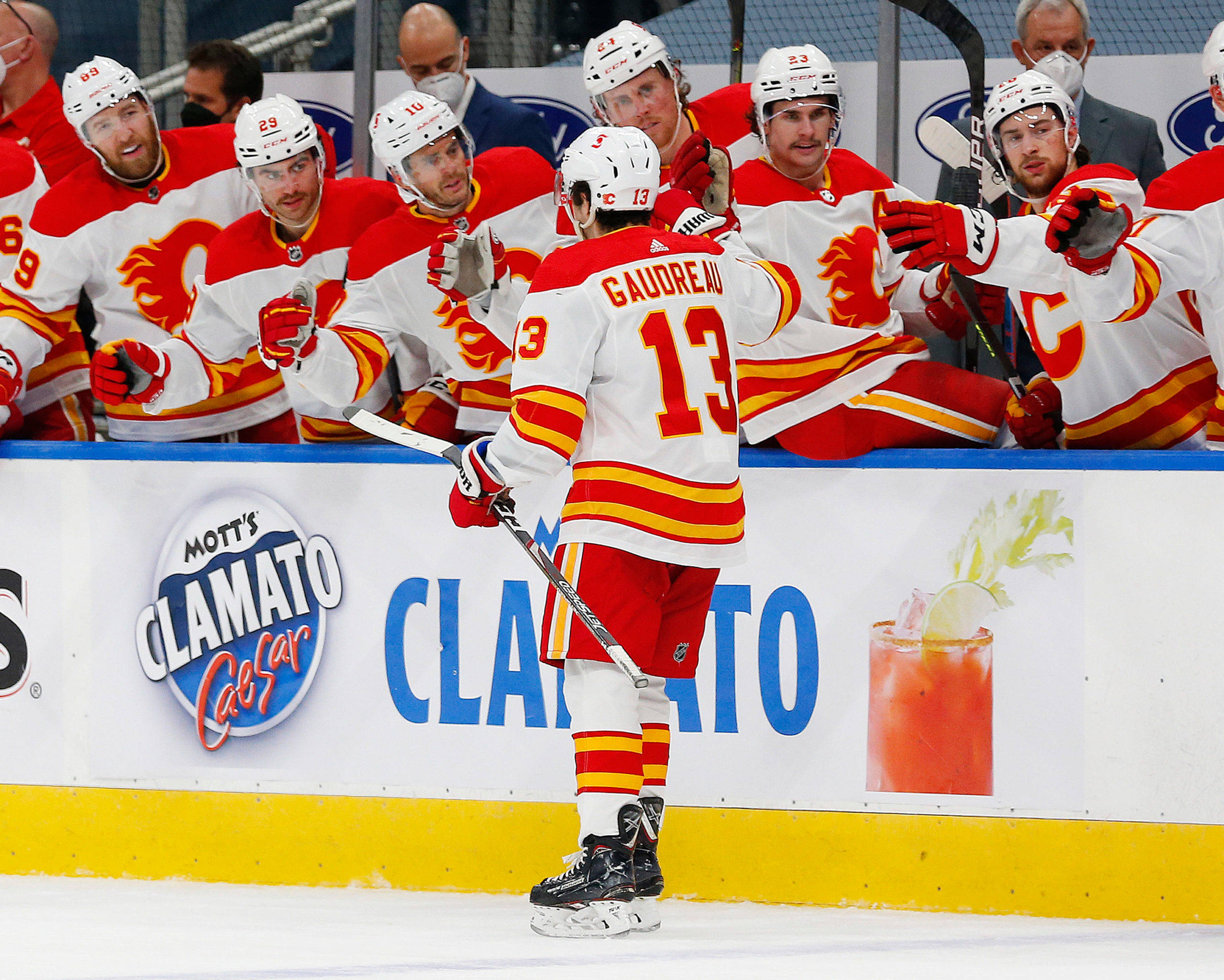 Johnny Gaudreau 桌布 壁紙 — 冰球運動員13號在比賽期間與隊友在冰場上慶祝，可見Mott's Clamato廣告。
